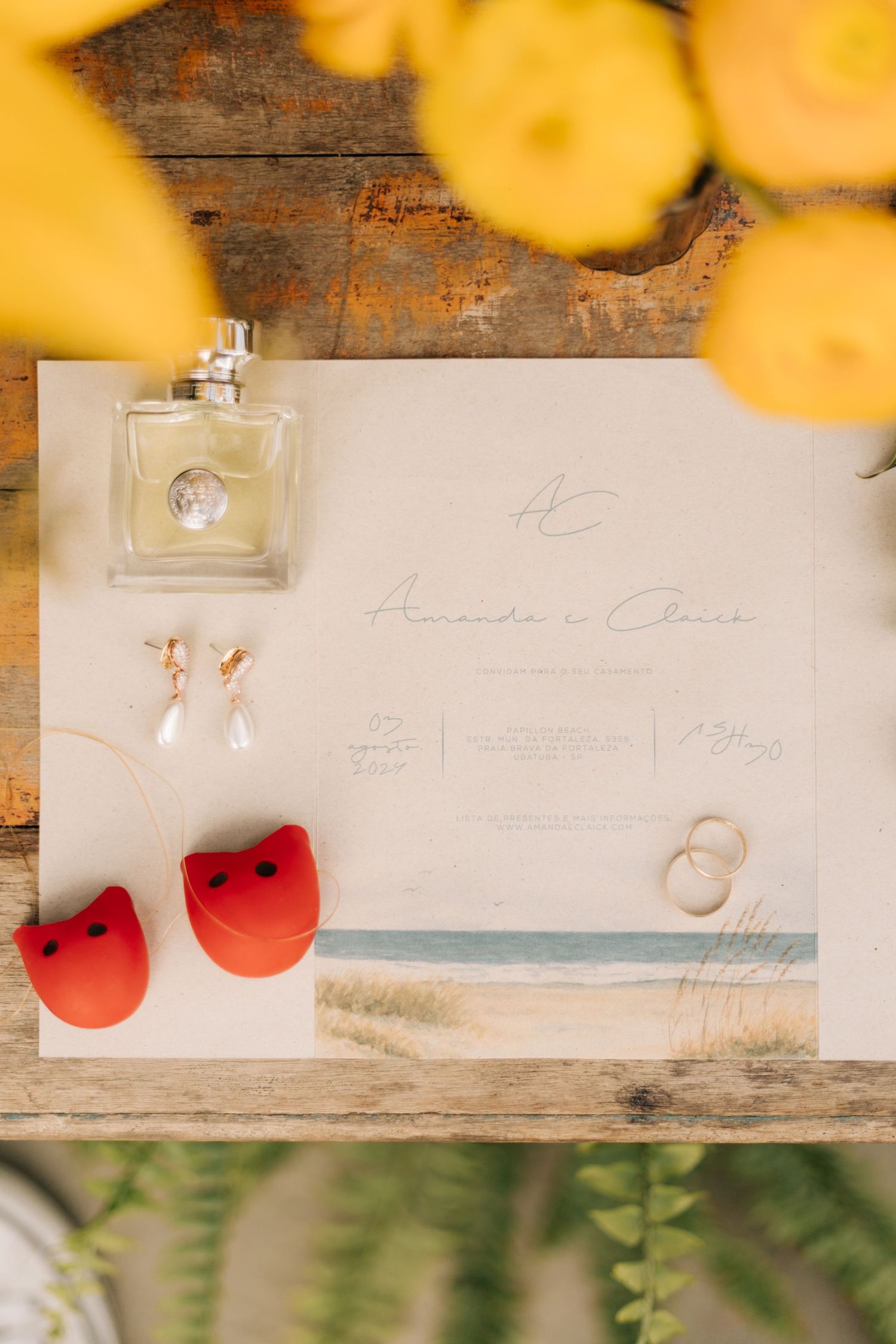 Wedding invitation details with watercolor accents and decorative elements on wooden surface.