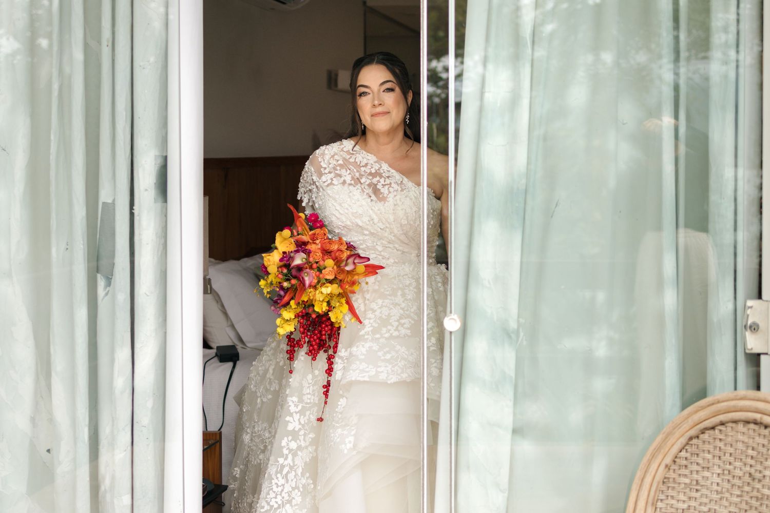 Elegant wedding venue interior with sheer white curtains and floral arrangements.