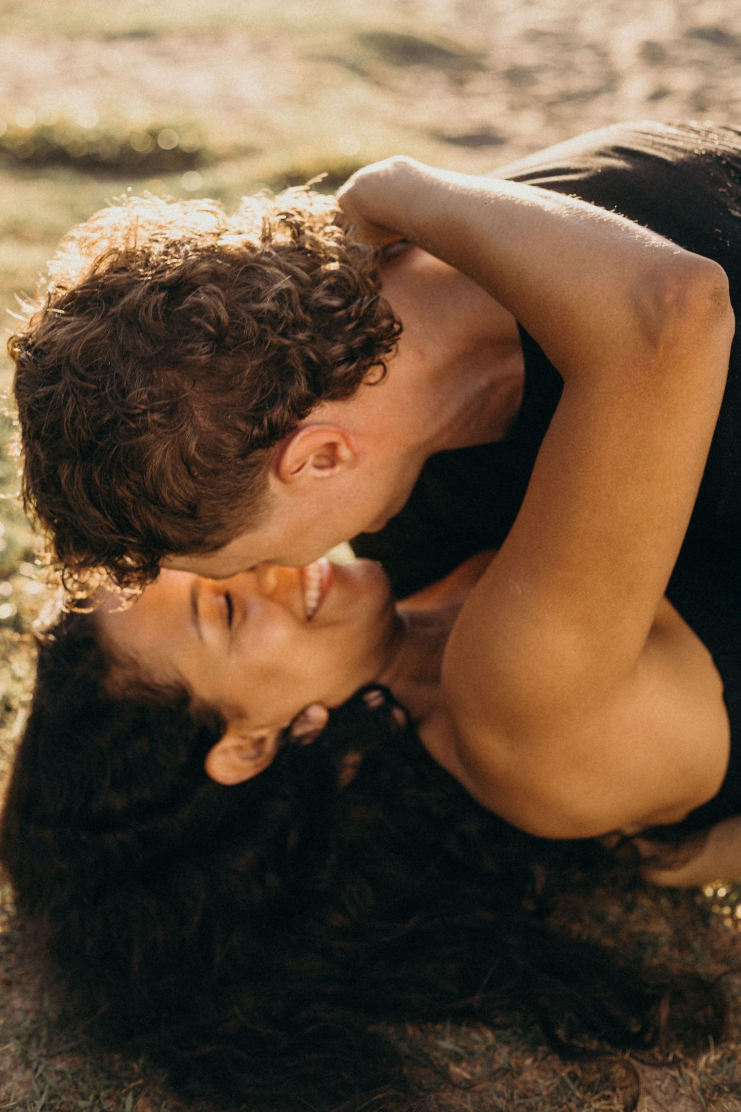 Intimate close-up portrait of couple sharing tender moment in warm sunlight.