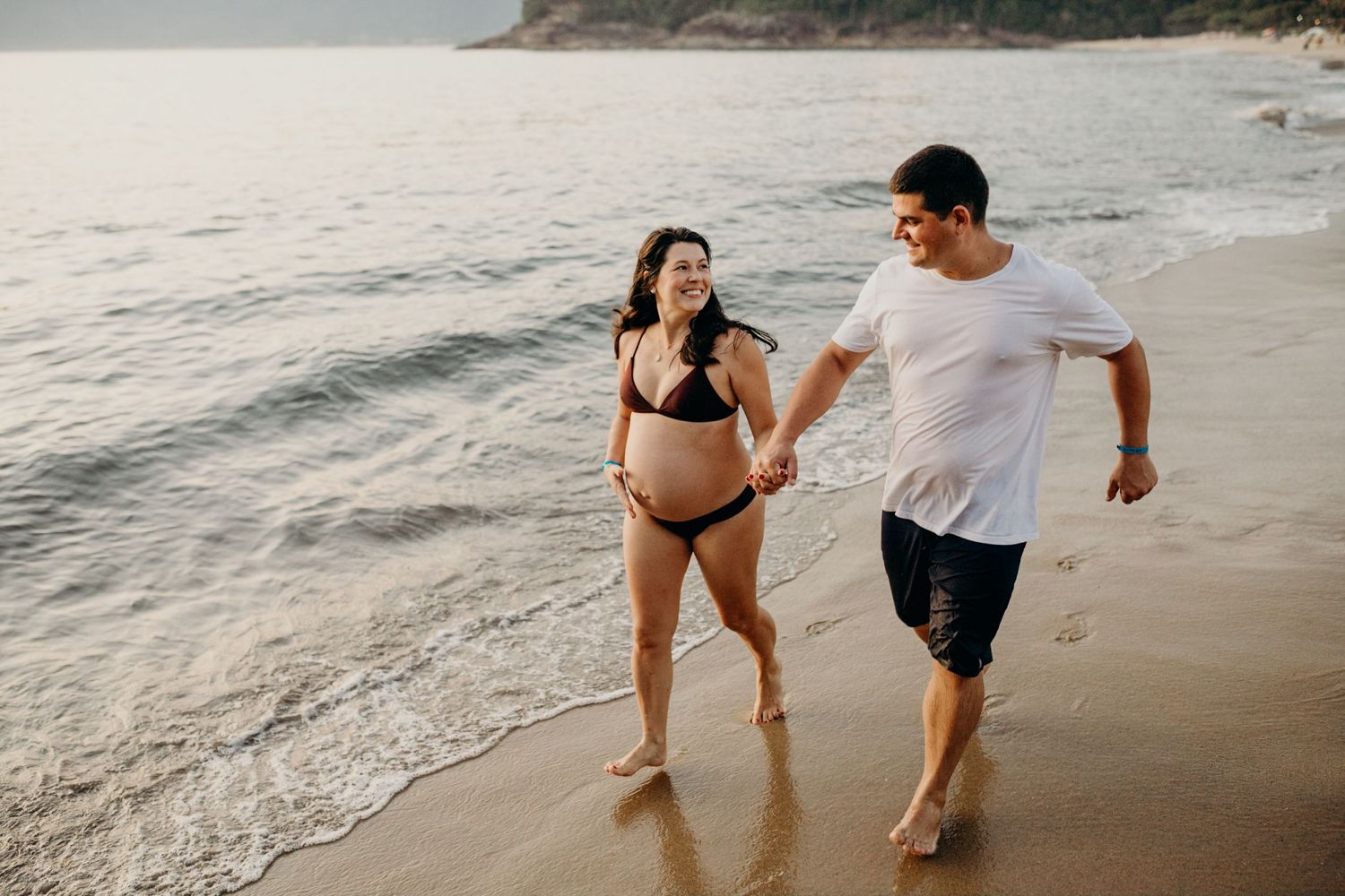 People enjoying a playful moment in the shallow waters at sunset.