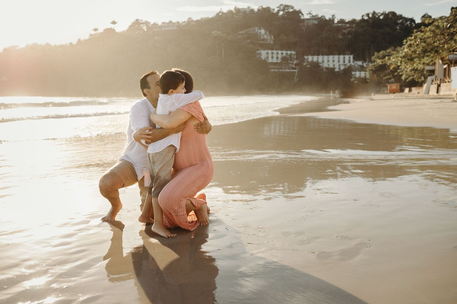 Couple sharing intimate moment in ocean waves during sunset.
