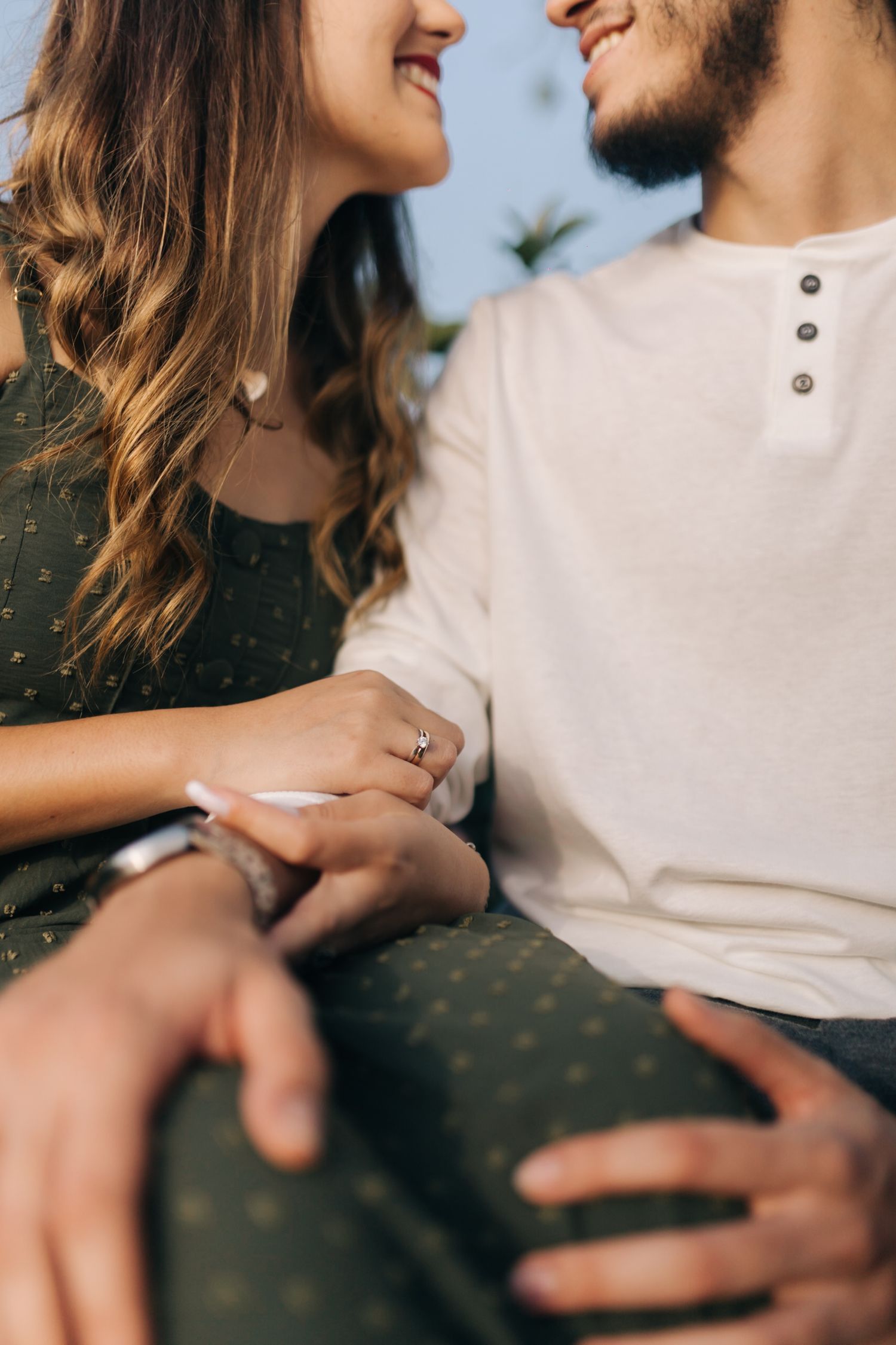 Candid close-up moment between couple in white and dark clothing outdoors.