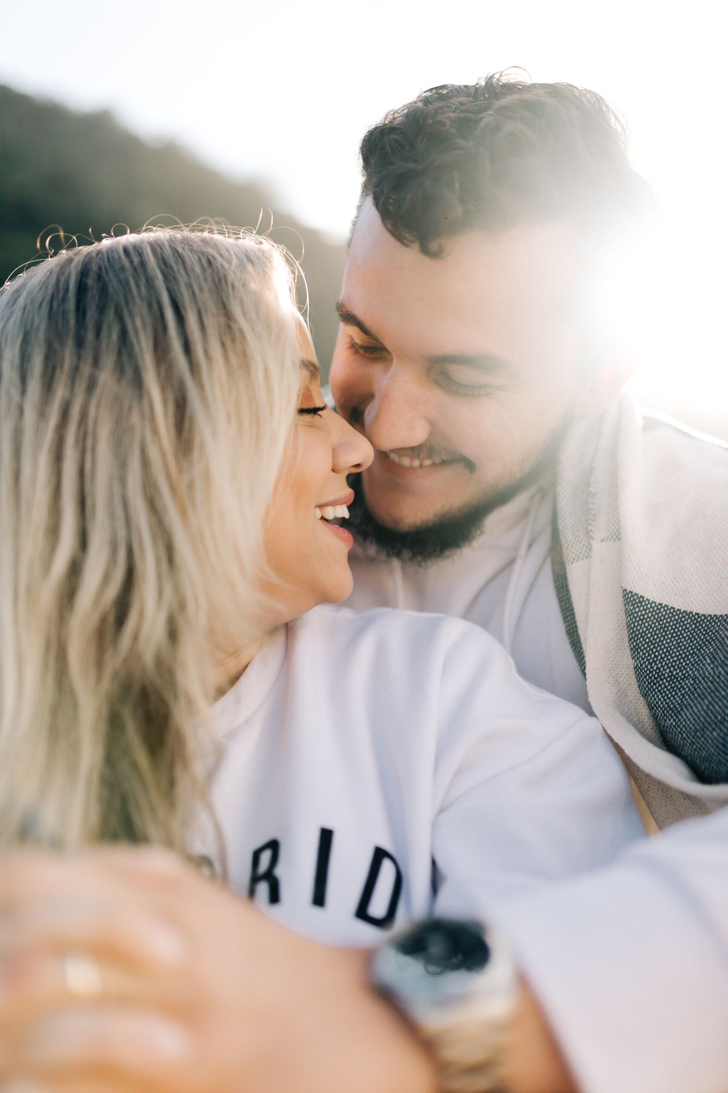 Intimate close-up of couple sharing loving moment on sunny beach.