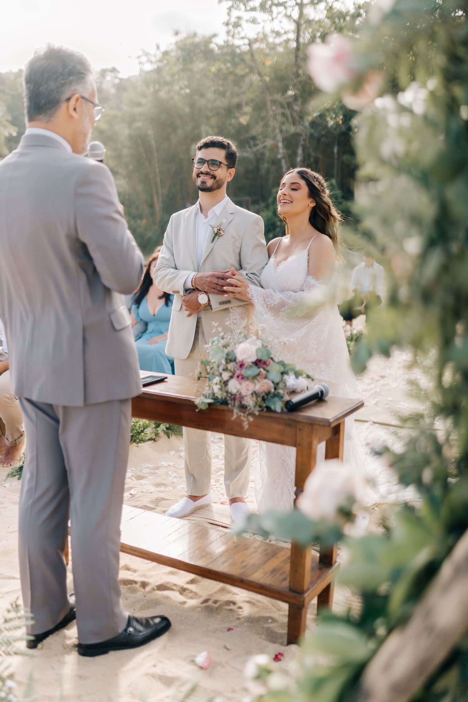 Wedding ceremony moments captured in natural outdoor beach setting with greenery.