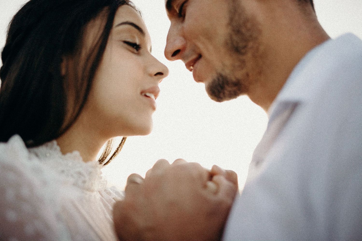 Close up portrait of loving couple in tender embrace against white background.