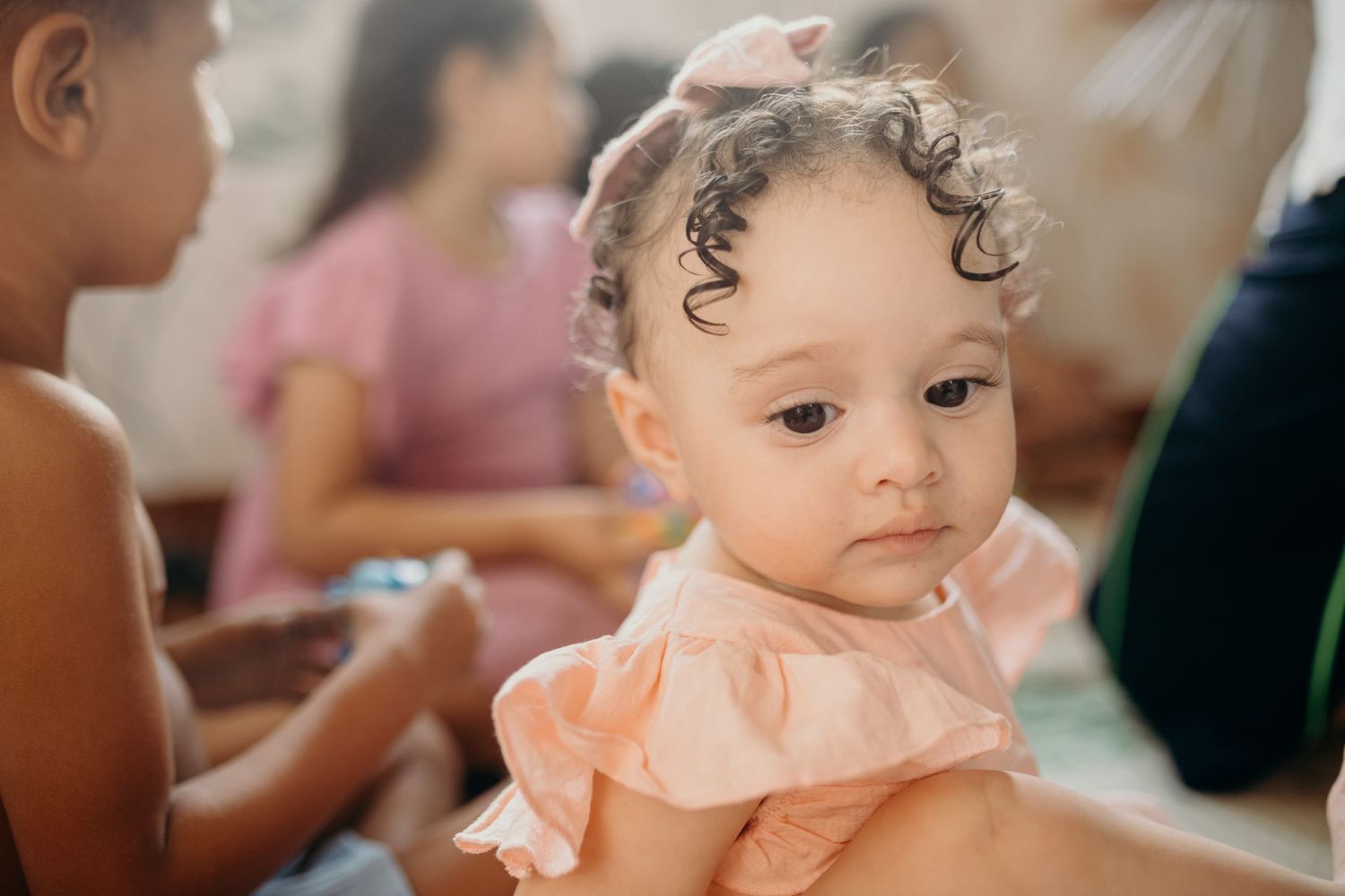A sweet moment during music therapy with a baby in peachy-pink attire.