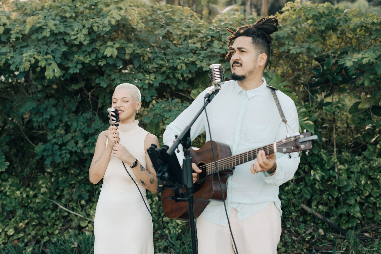Musicians performing with guitar and microphone at an outdoor event.