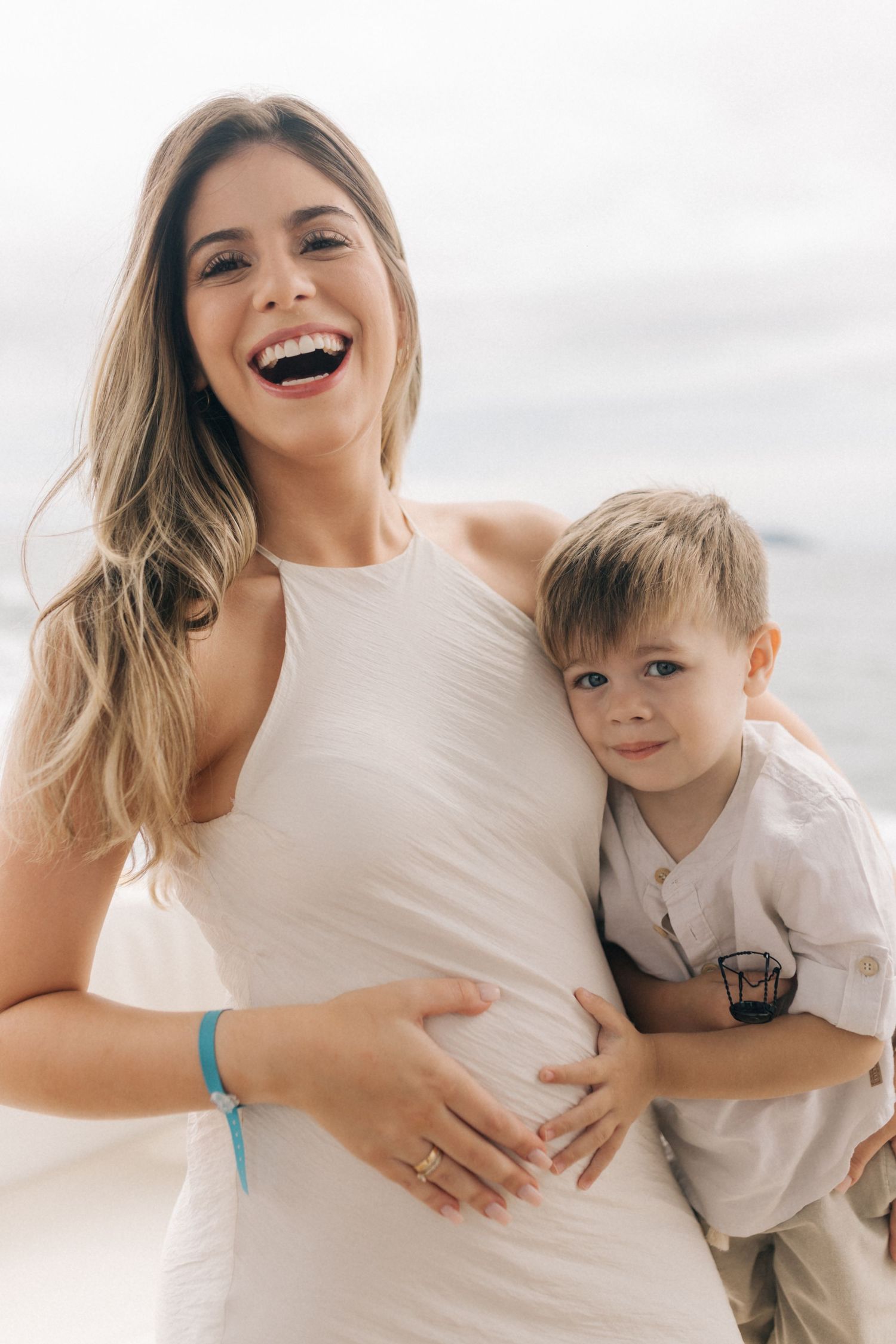 Happy moment showing heartwarming embrace of parent and child against cloudy sky.