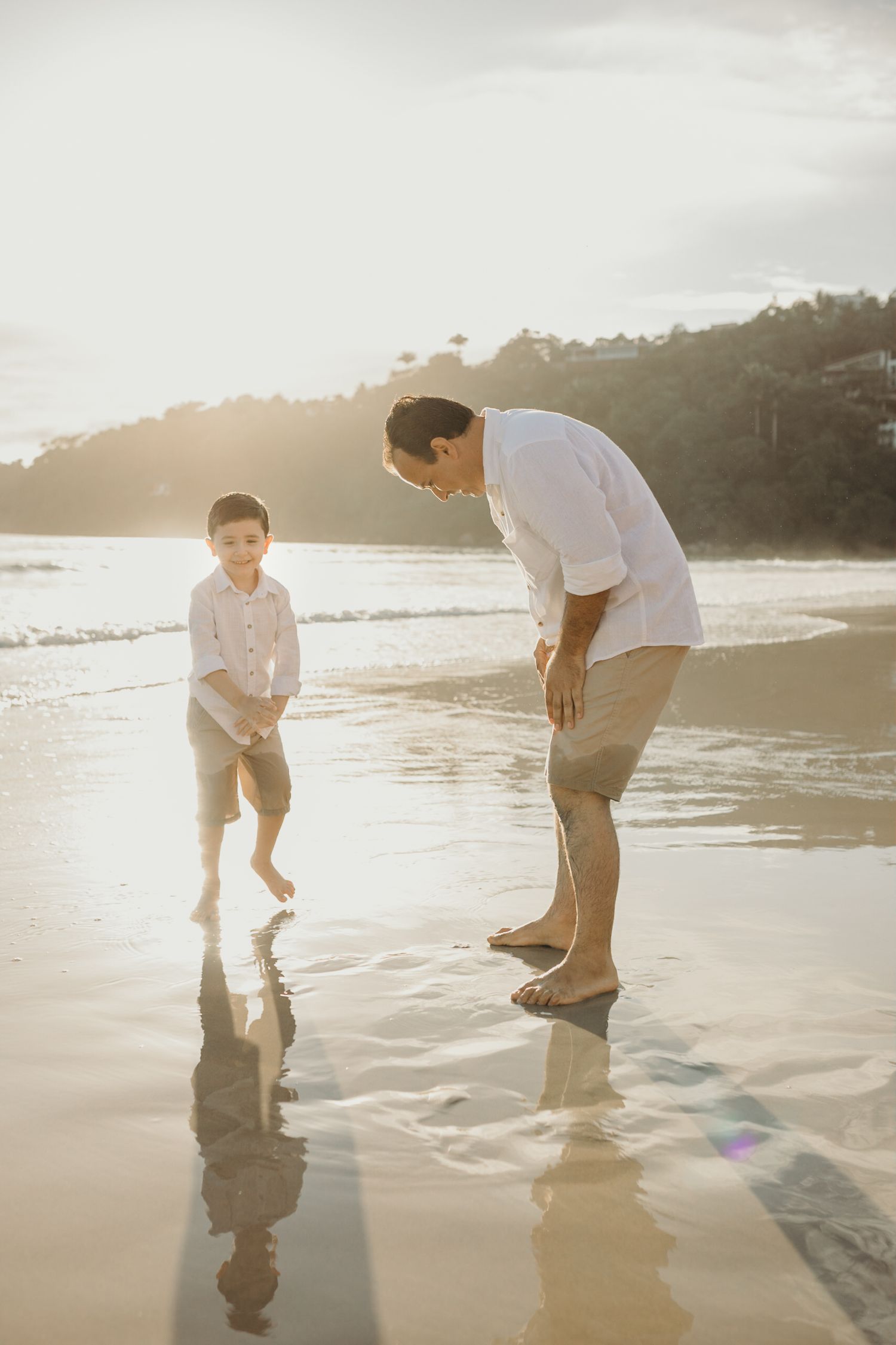 A playful moment at sunset on the beach with reflections in the wet sand.