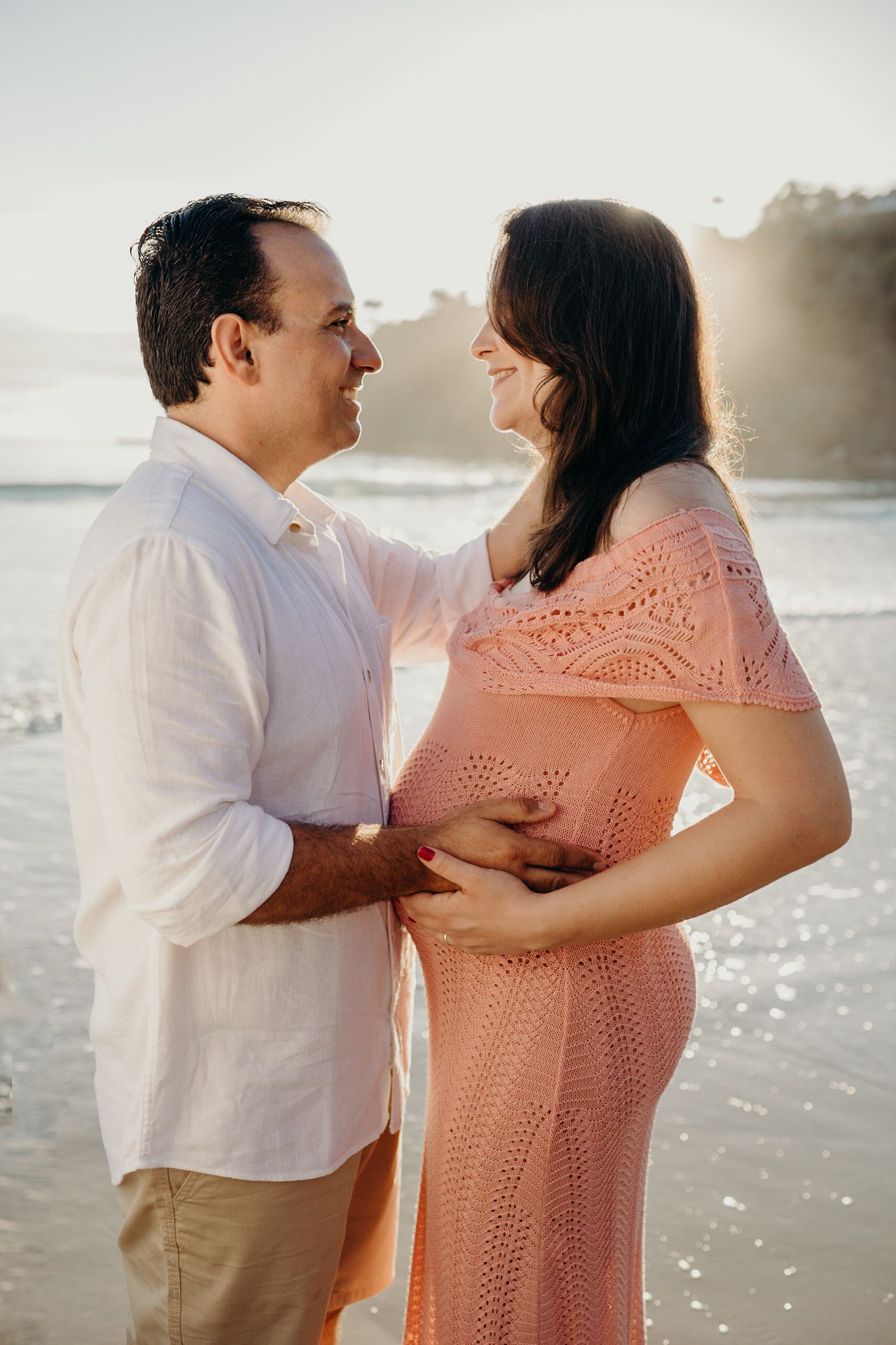 Intimate family portrait session on the beach with beautiful golden sunlight.