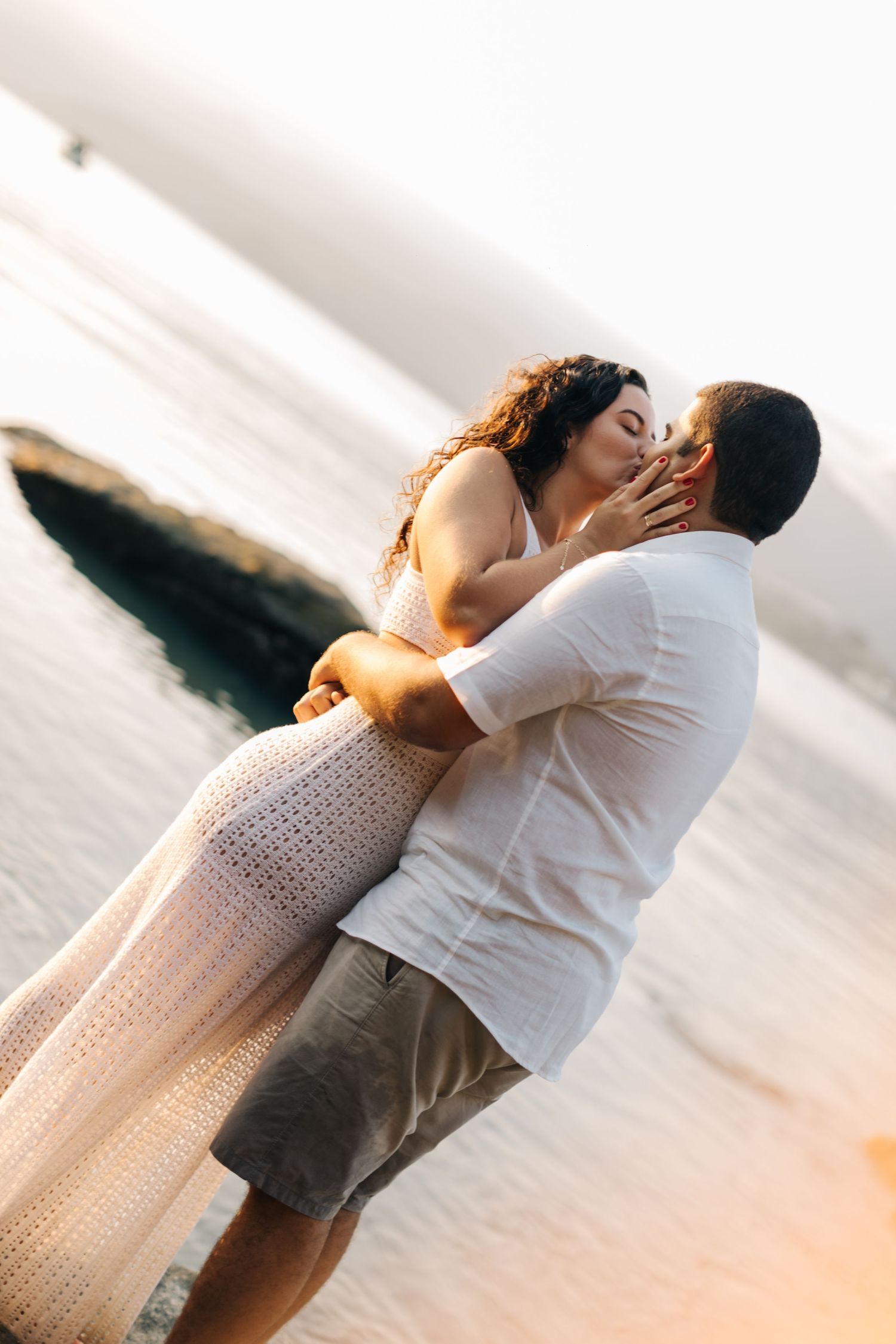 Romantic beachside embrace during golden hour photography session.
