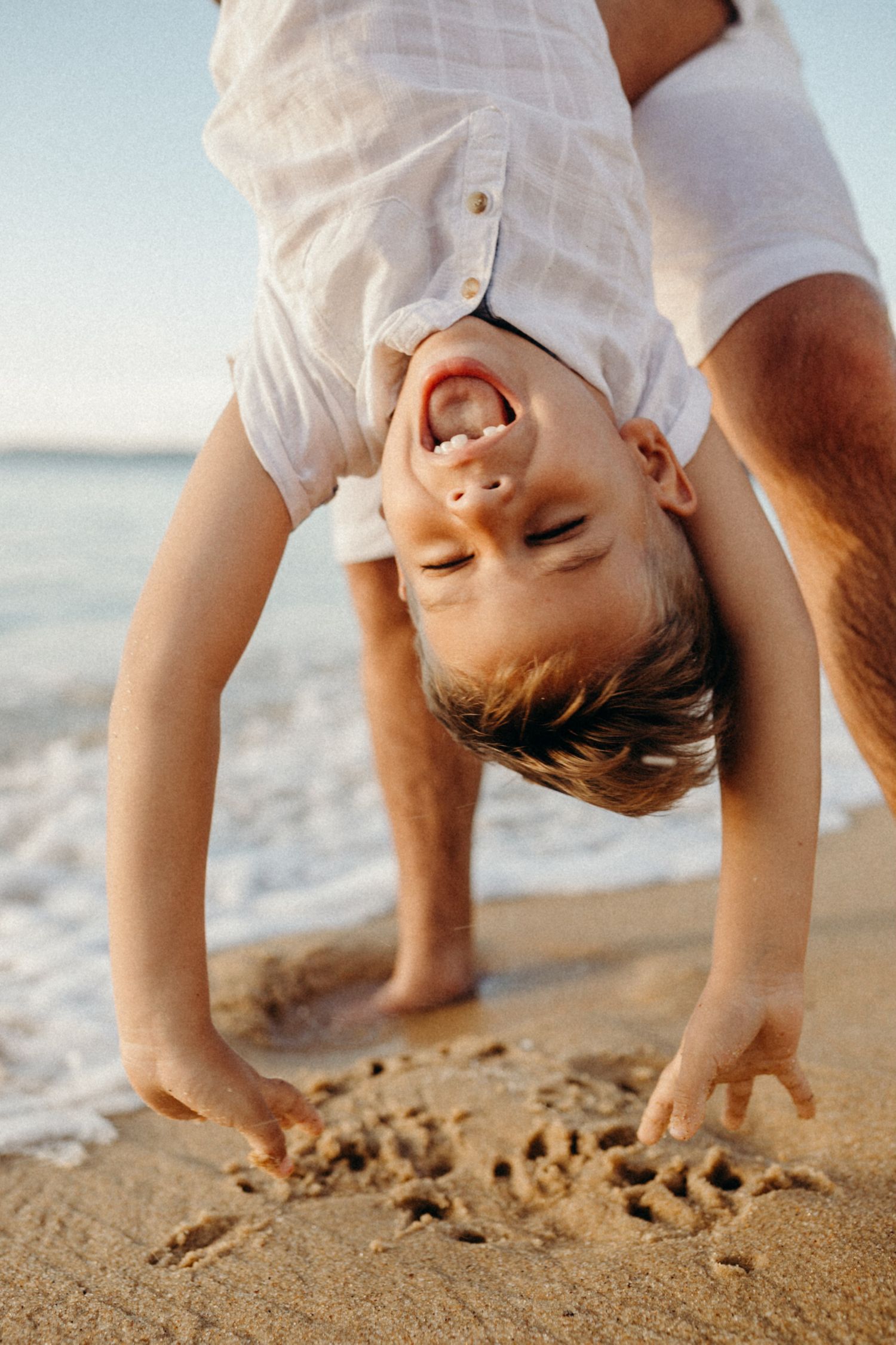 Close-up sequence of joyful play at the beach near the water's edge.