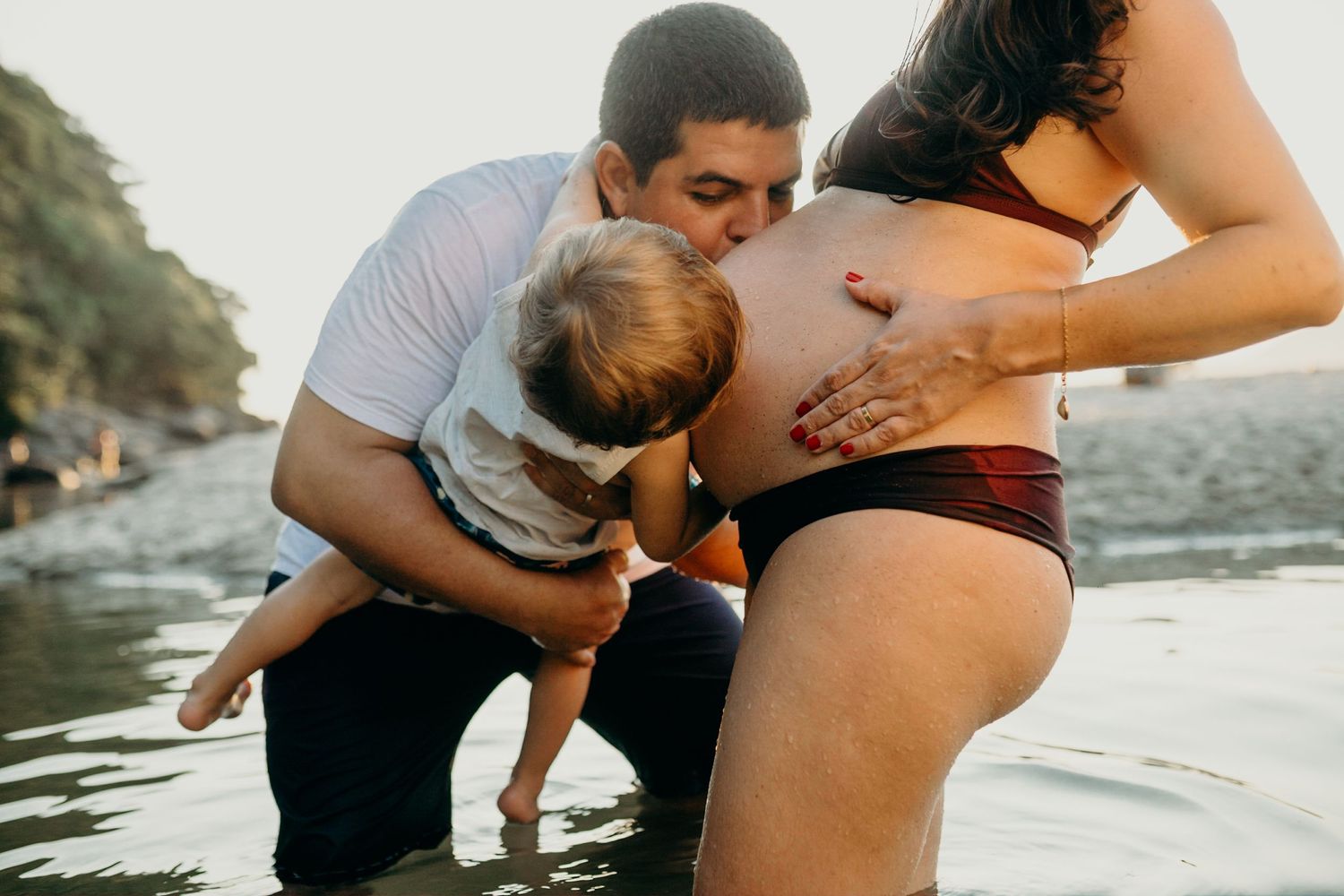 Intimate sunset maternity photoshoot by the water's edge.