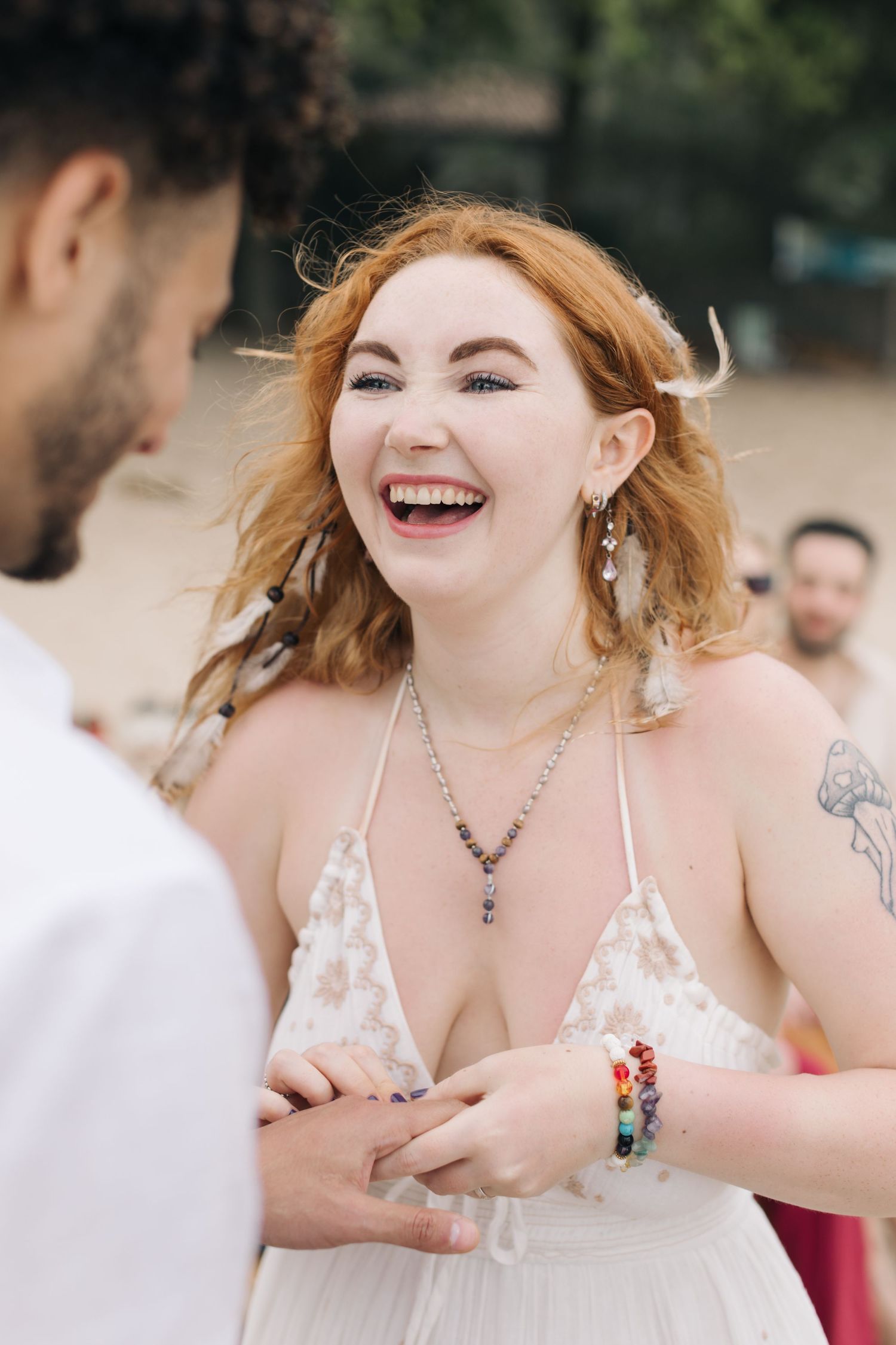 Emotional exchange during beachside wedding ceremony with natural scenery in background.