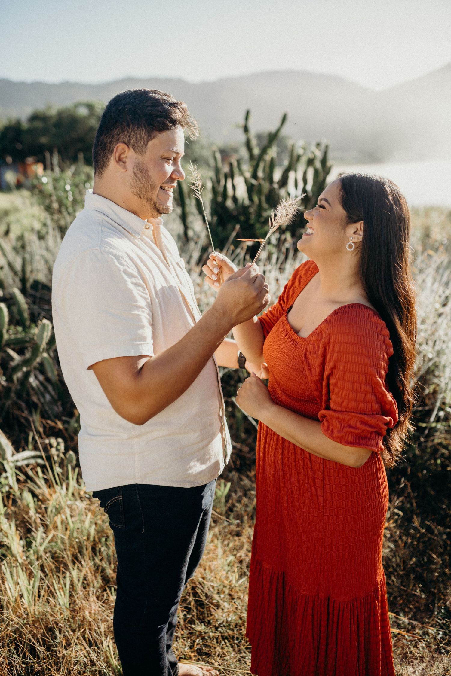 Couple shares an intimate moment against a scenic mountain backdrop with desert plants.