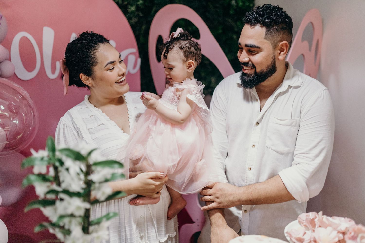 Family celebration moment with pink balloon decorations and smiles.