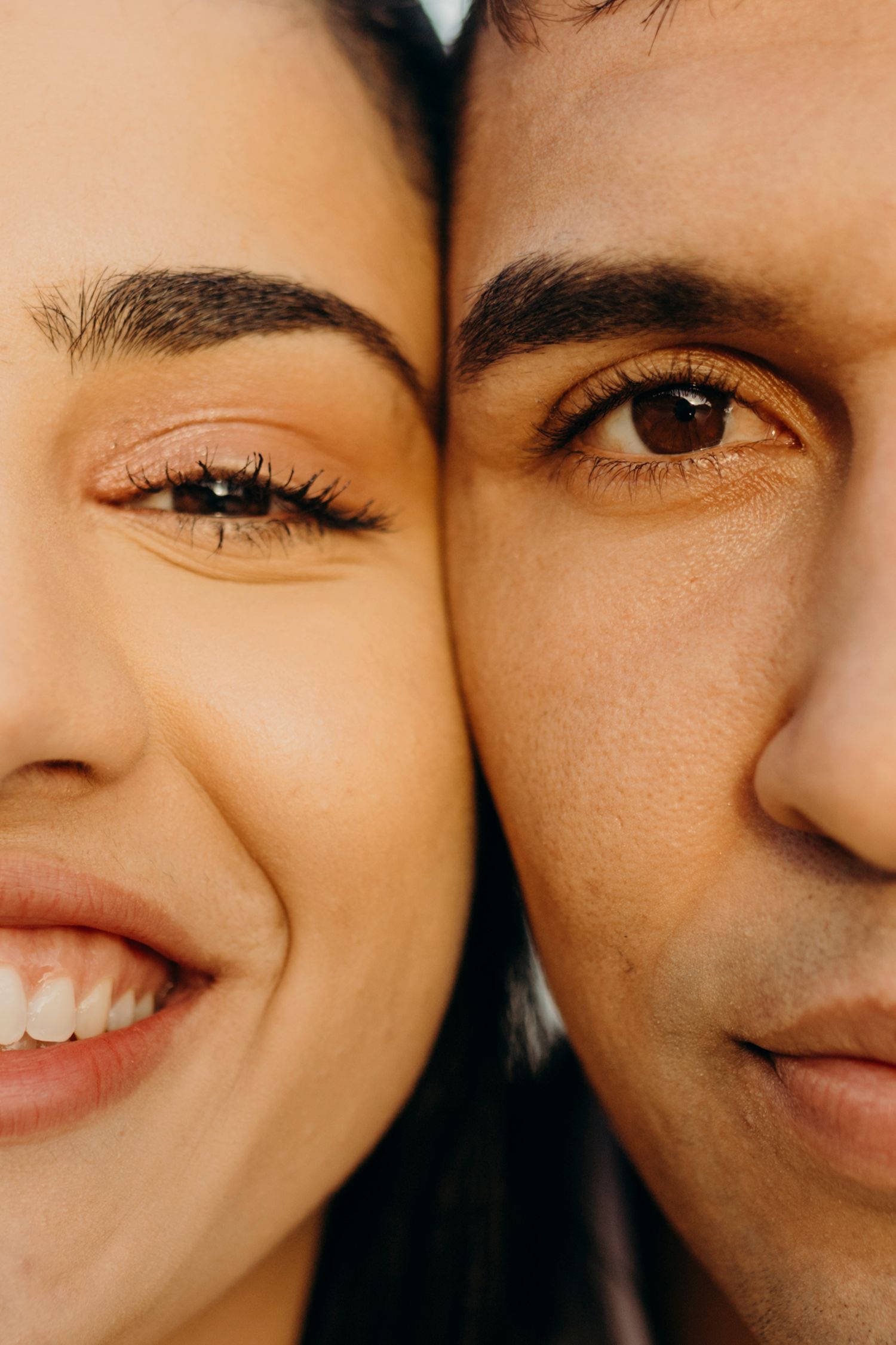Close up portrait of a couple's faces touching as they smile warmly.