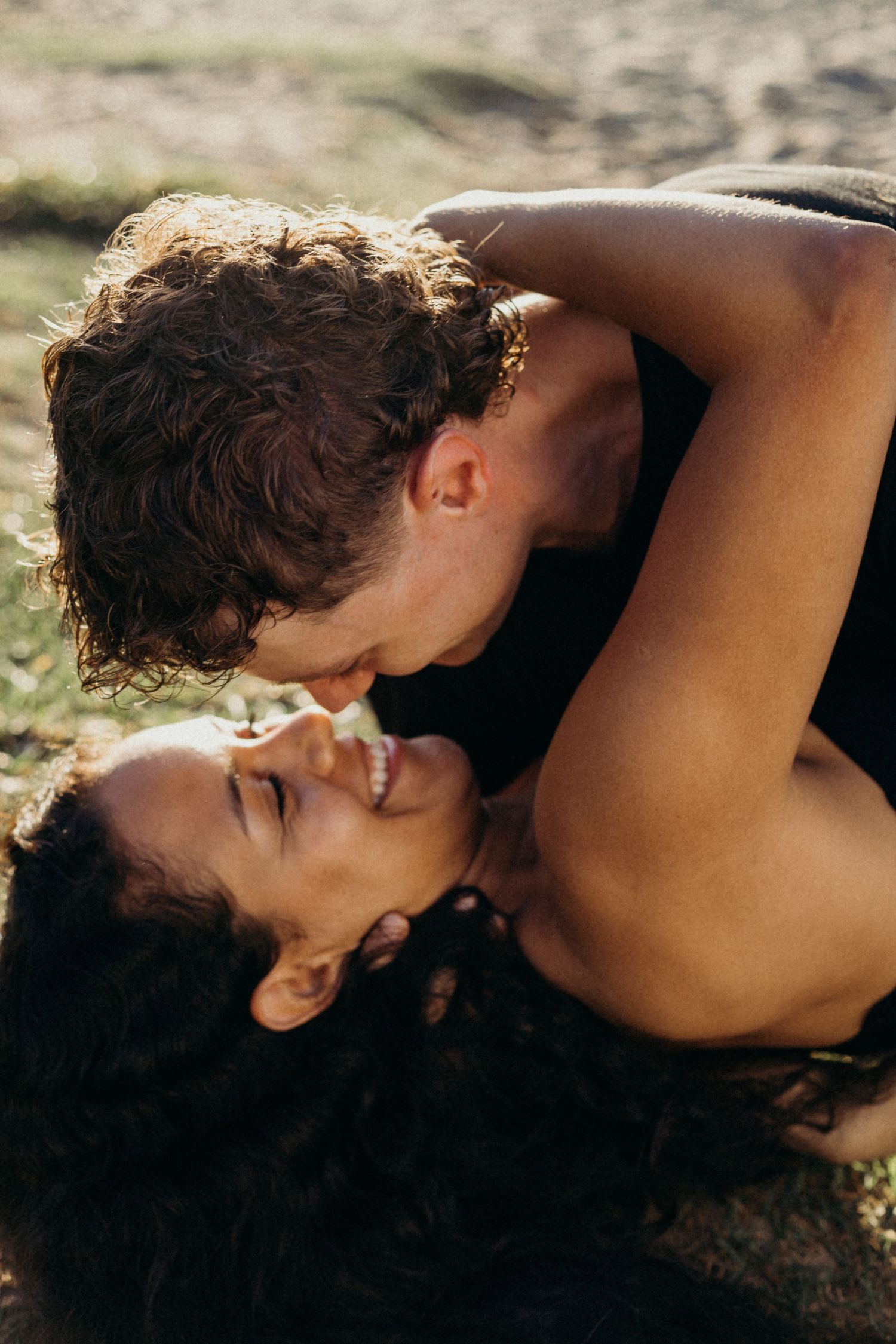 Joyful couple sharing an intimate moment outdoors in natural lighting.