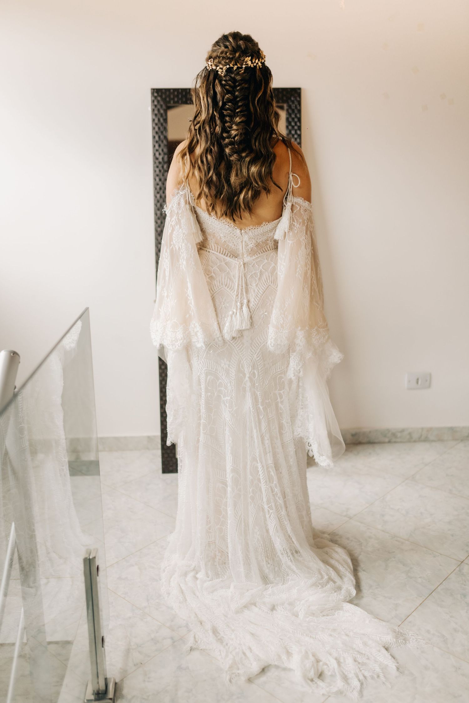 Back view of wedding dress showing intricate lace details and flowing train.