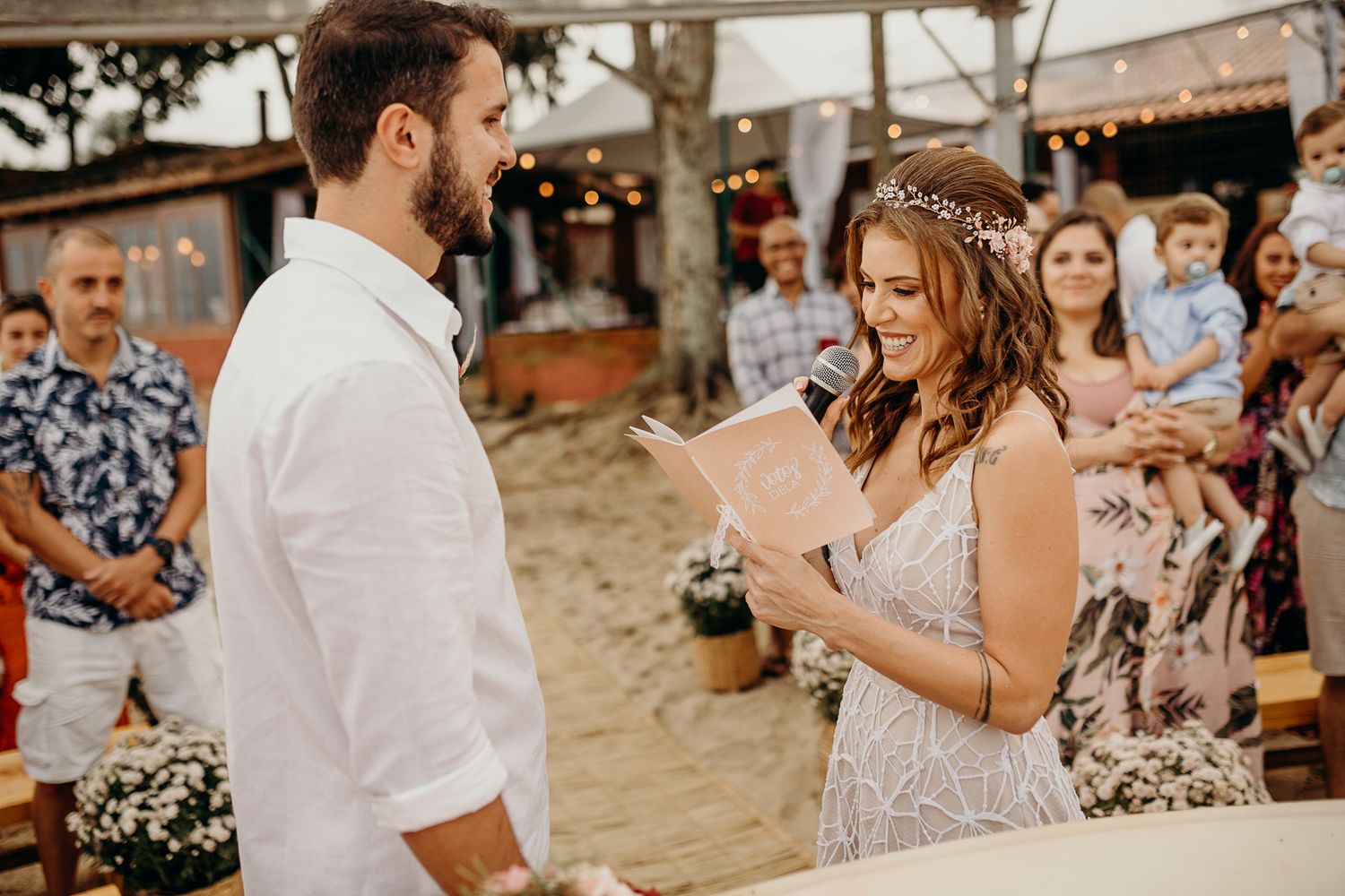Wedding celebration under string lights with guests enjoying the outdoor festivities.