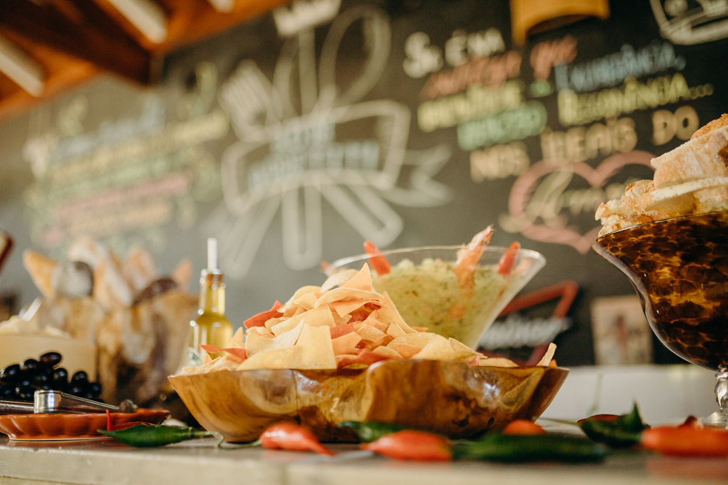 Tortilla chips displayed on a serving platter against a chalkboard wall with decorative writing.