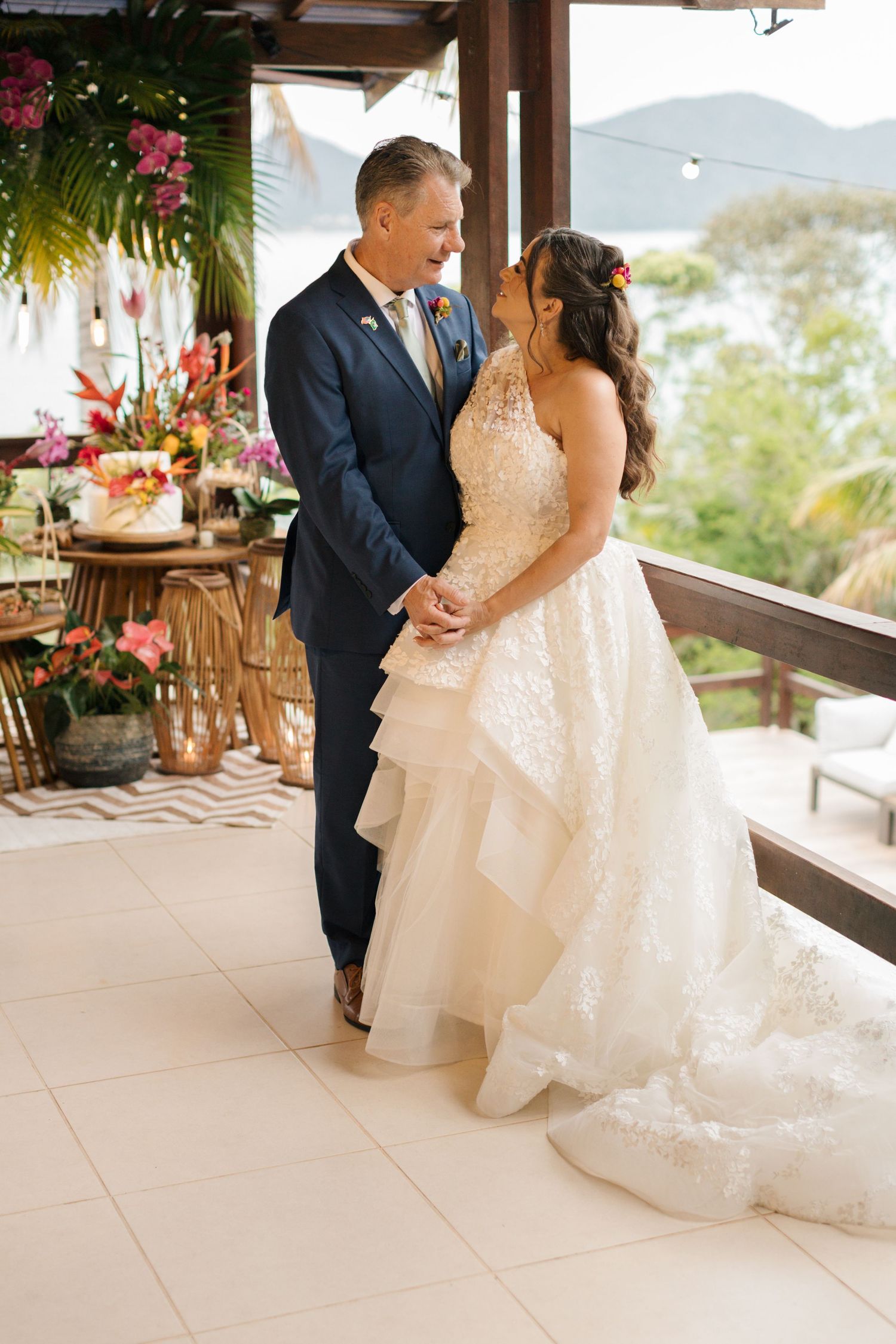 A couple shares intimate moments on a covered terrace with mountain views and tropical decor.