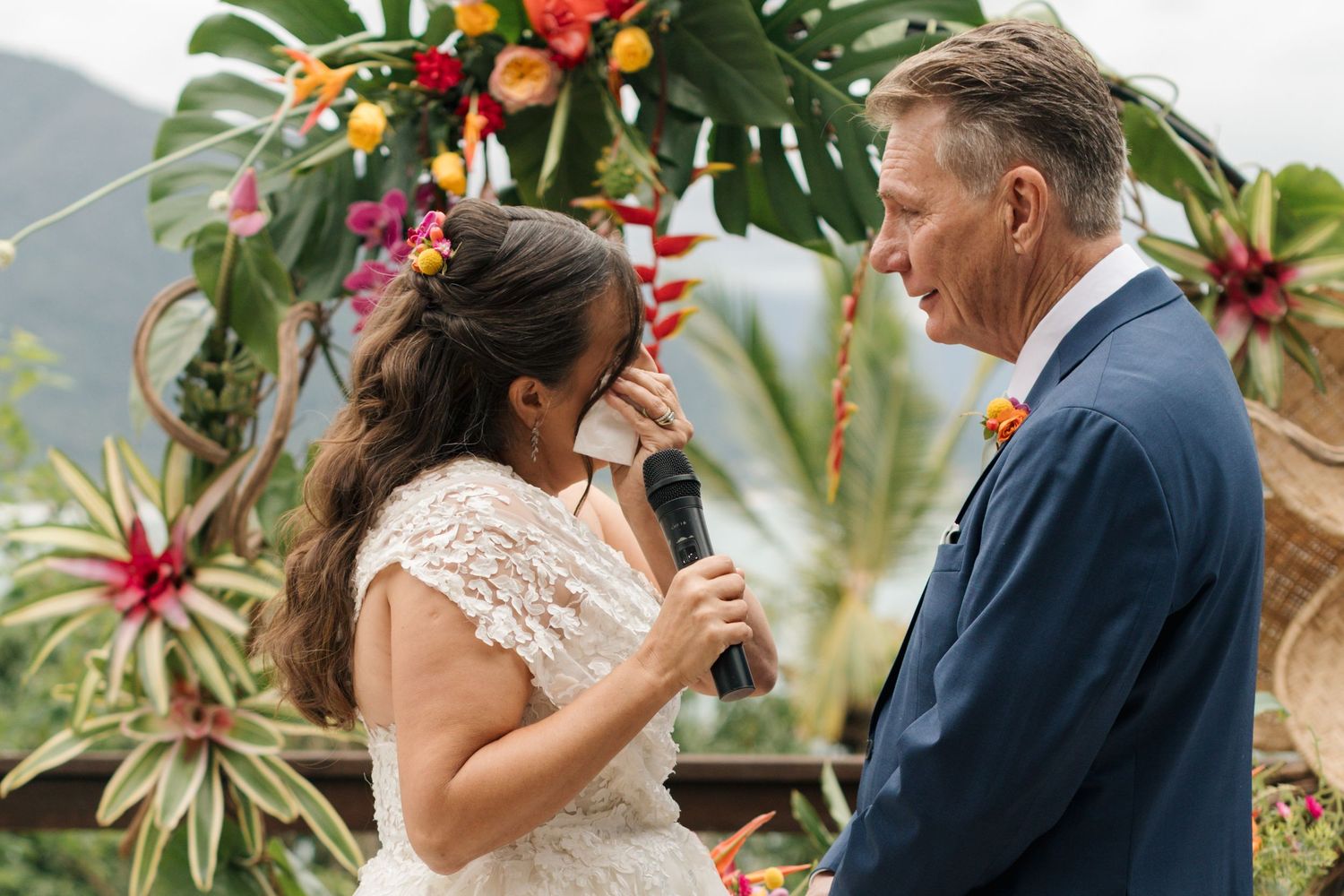 Emotional wedding ceremony moments on a tropical deck with colorful floral arrangements.