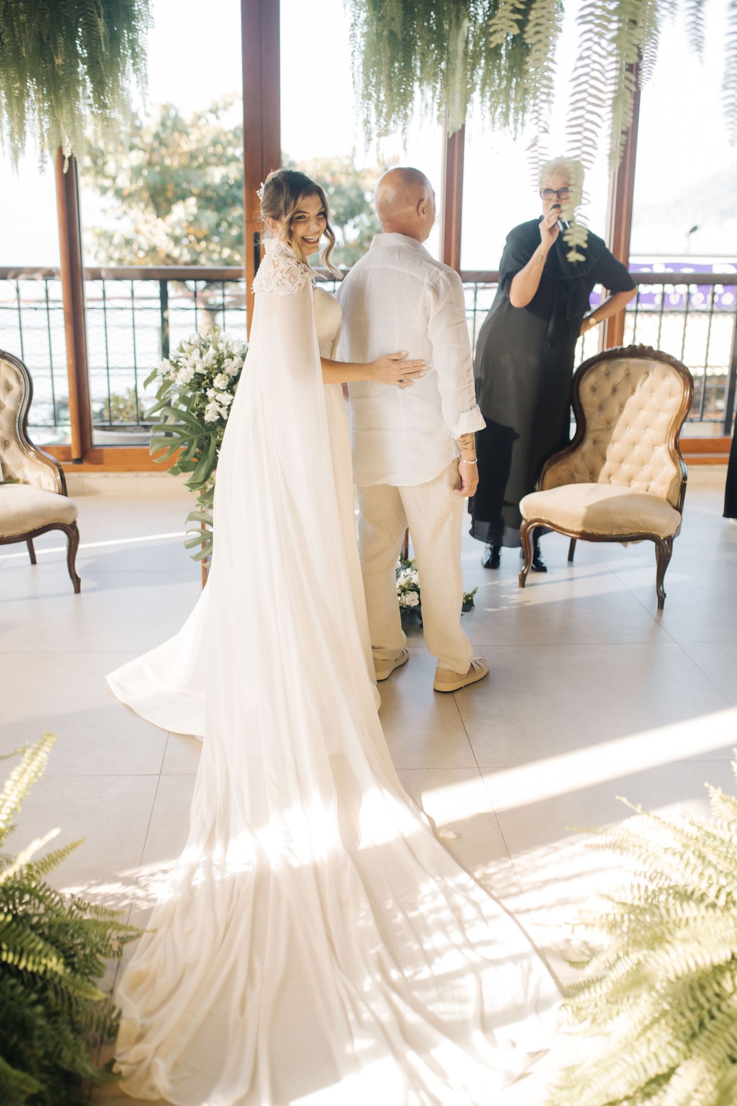 Wedding ceremony space with flowing white dresses, vintage furniture, and cascading greenery.