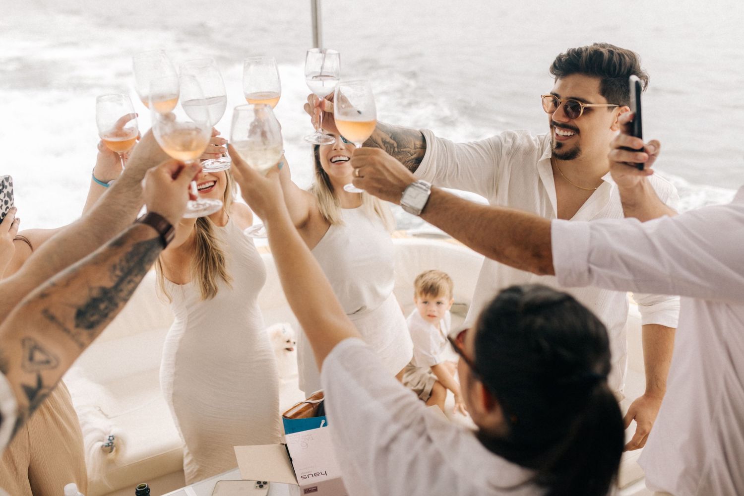 Celebration on a boat with friends toasting and raising their glasses together.