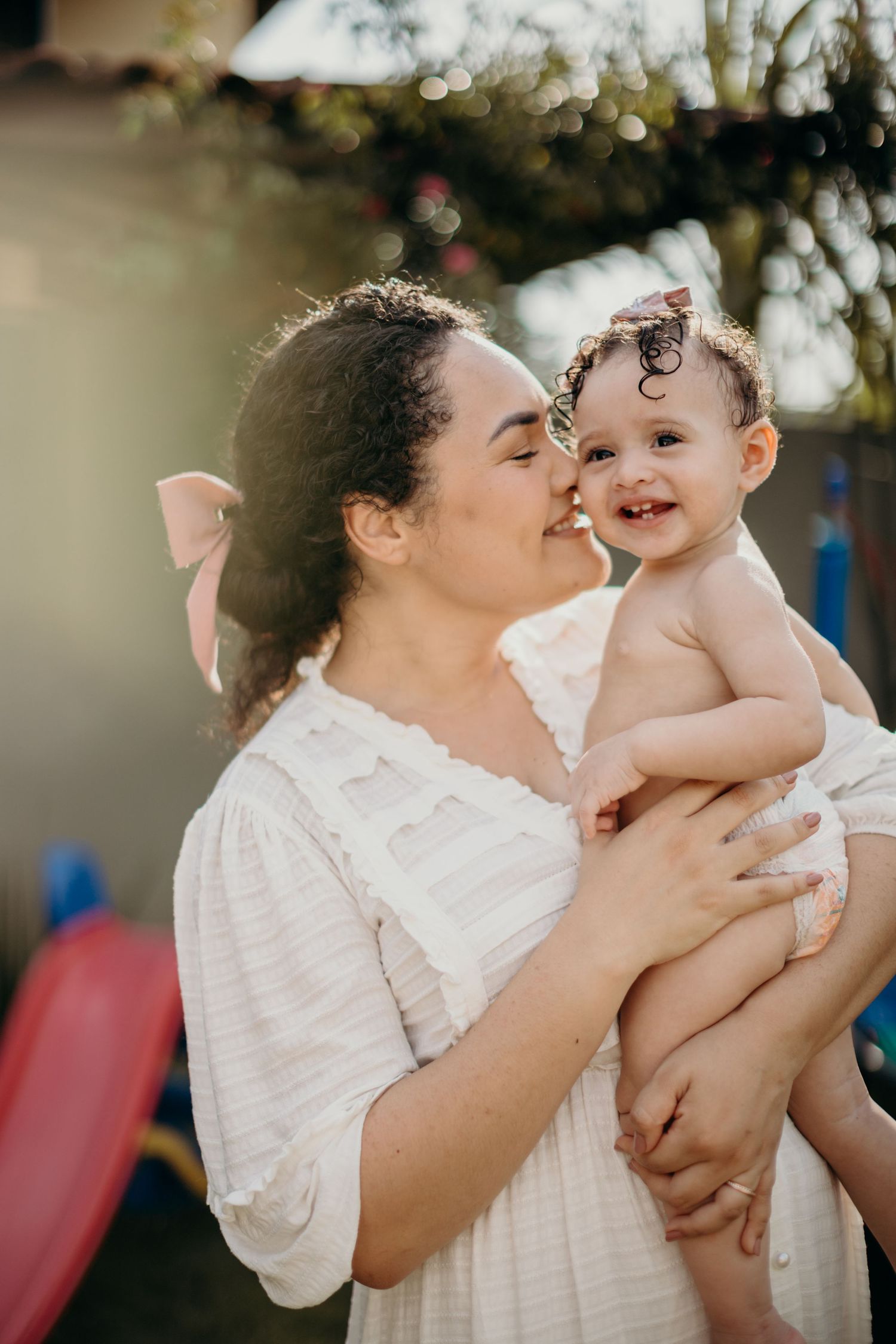 A sweet embrace between parent and child captured in warm afternoon sunlight.