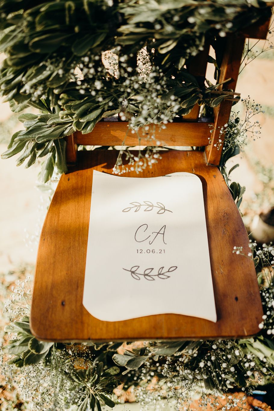 Handwritten table cards with floral decorations on wooden surface for event seating.