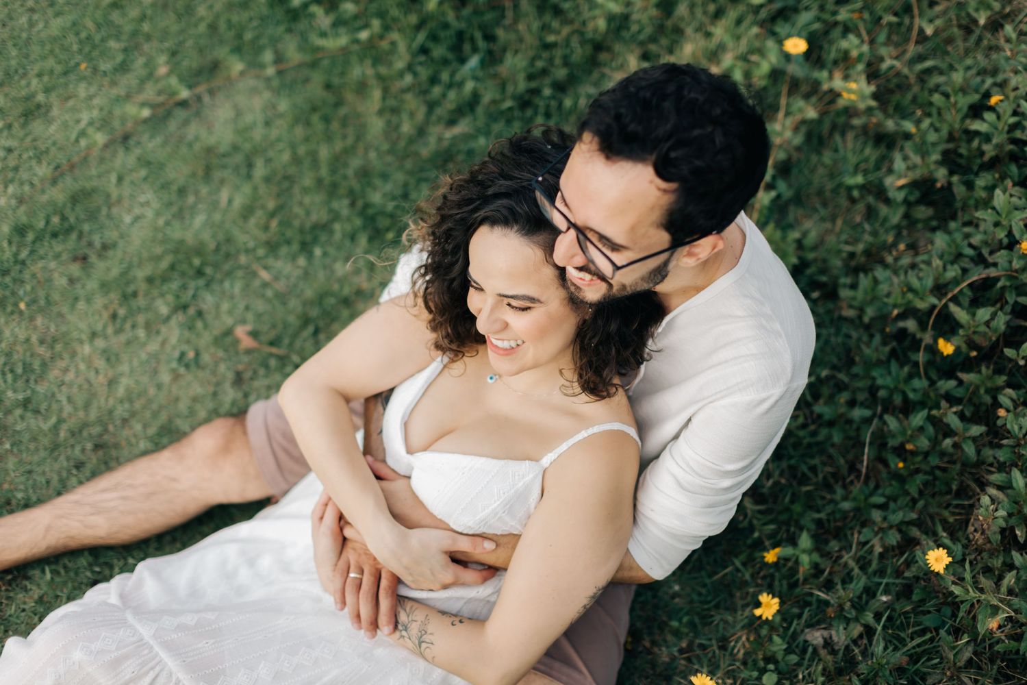 Romantic couple photos taken while laying on grass during outdoor session.