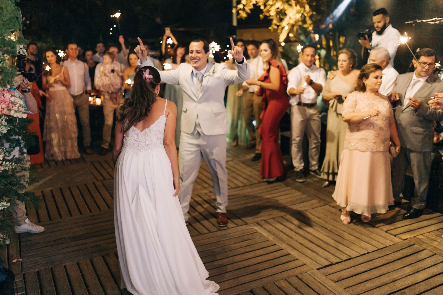 Couple performs a romantic dance move during their wedding reception as guests cheer.