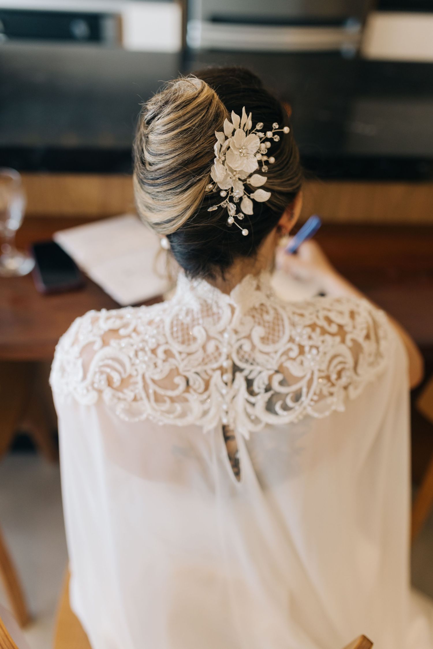 Detail shot of intricate lace back wedding dress with pearl hair accessories.