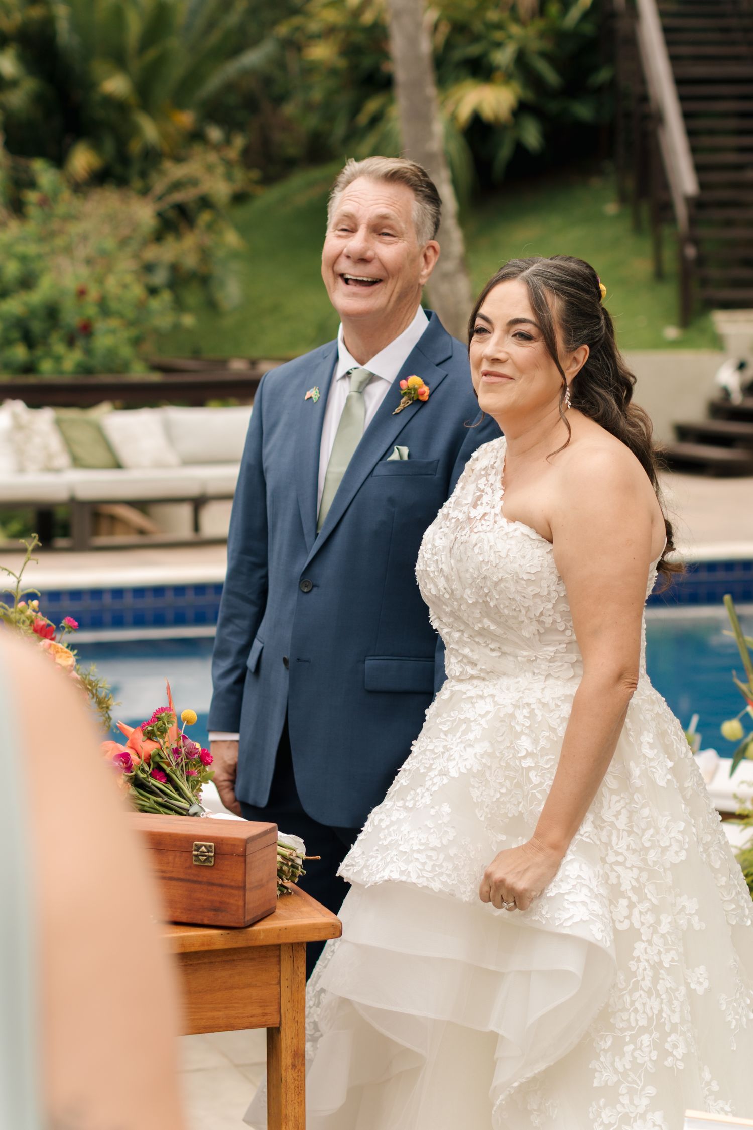 A joyful wedding moment captured by a swimming pool with elegant decorations.