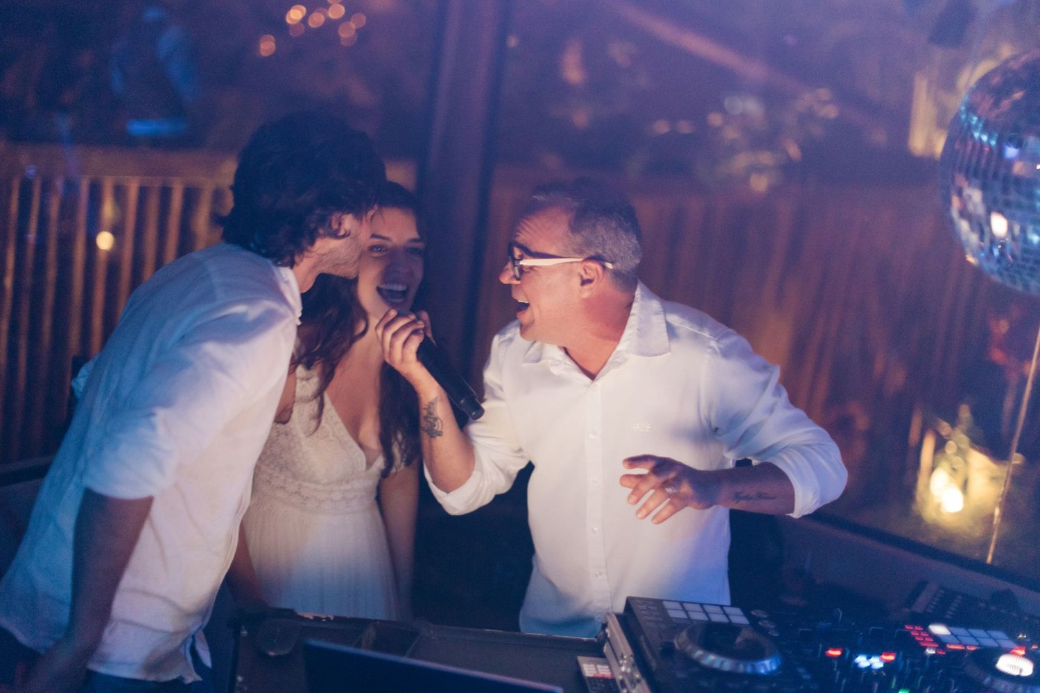 People dancing and celebrating at a dimly lit evening party venue.
