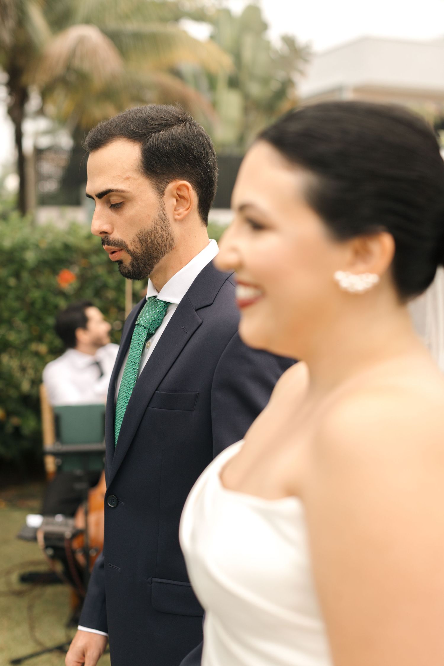 Wedding couple captured in an intimate moment against a garden backdrop with elegant attire.
