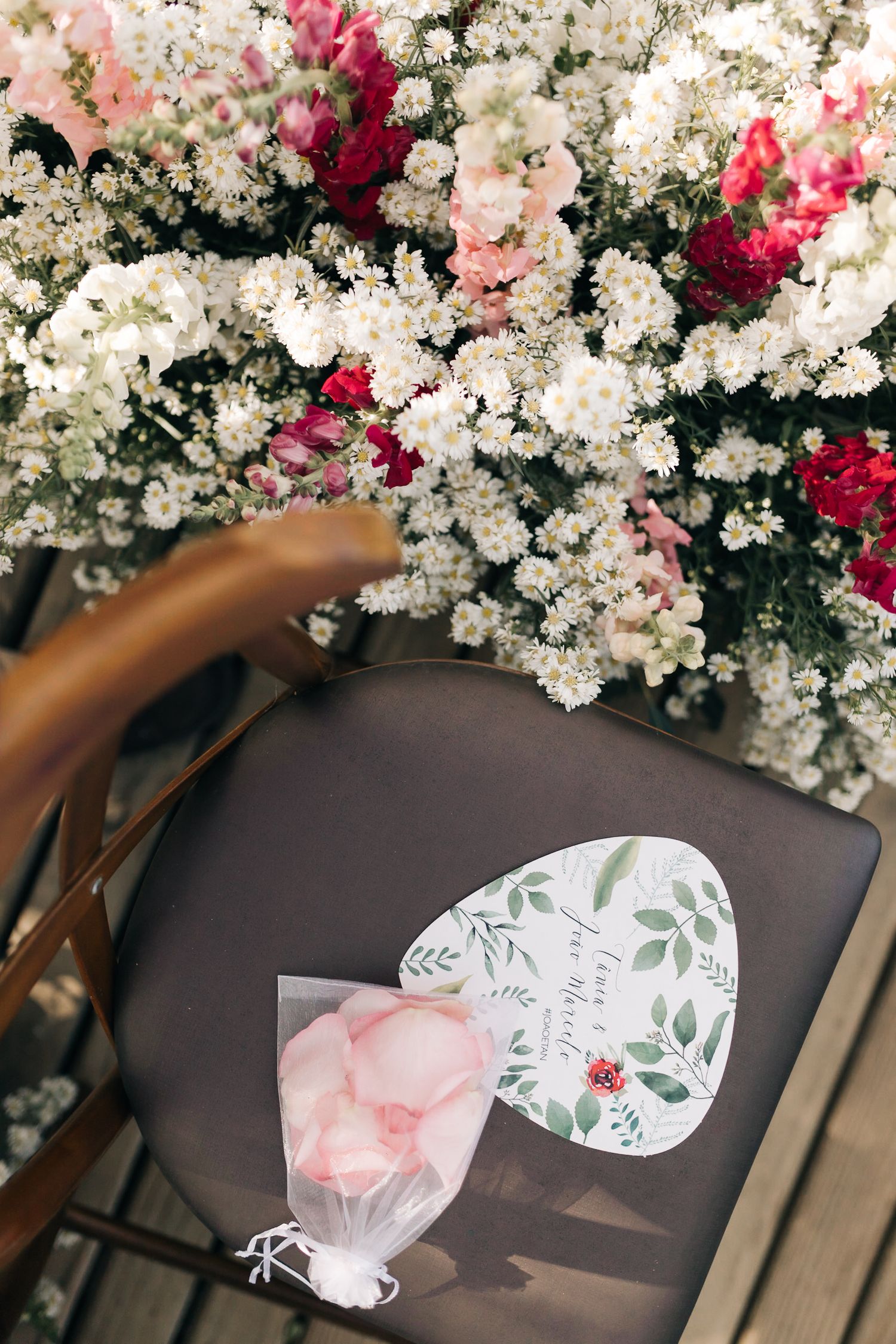 White and burgundy floral arrangements with decorative place cards on wooden tables.