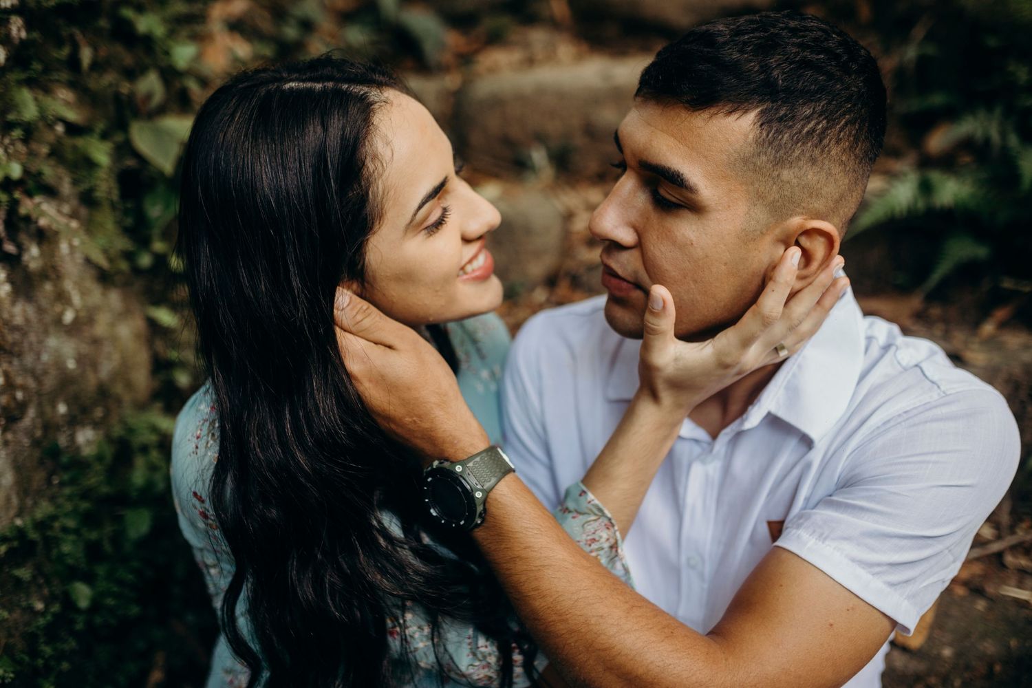 Intimate close-up of couple sharing tender moment against natural backdrop.