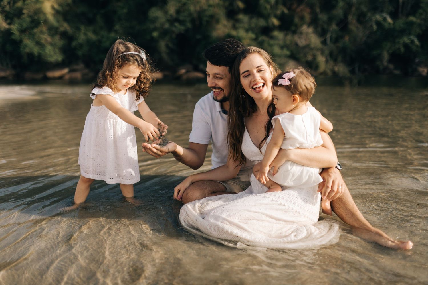 Intimate family moment shared while relaxing in beach waters.