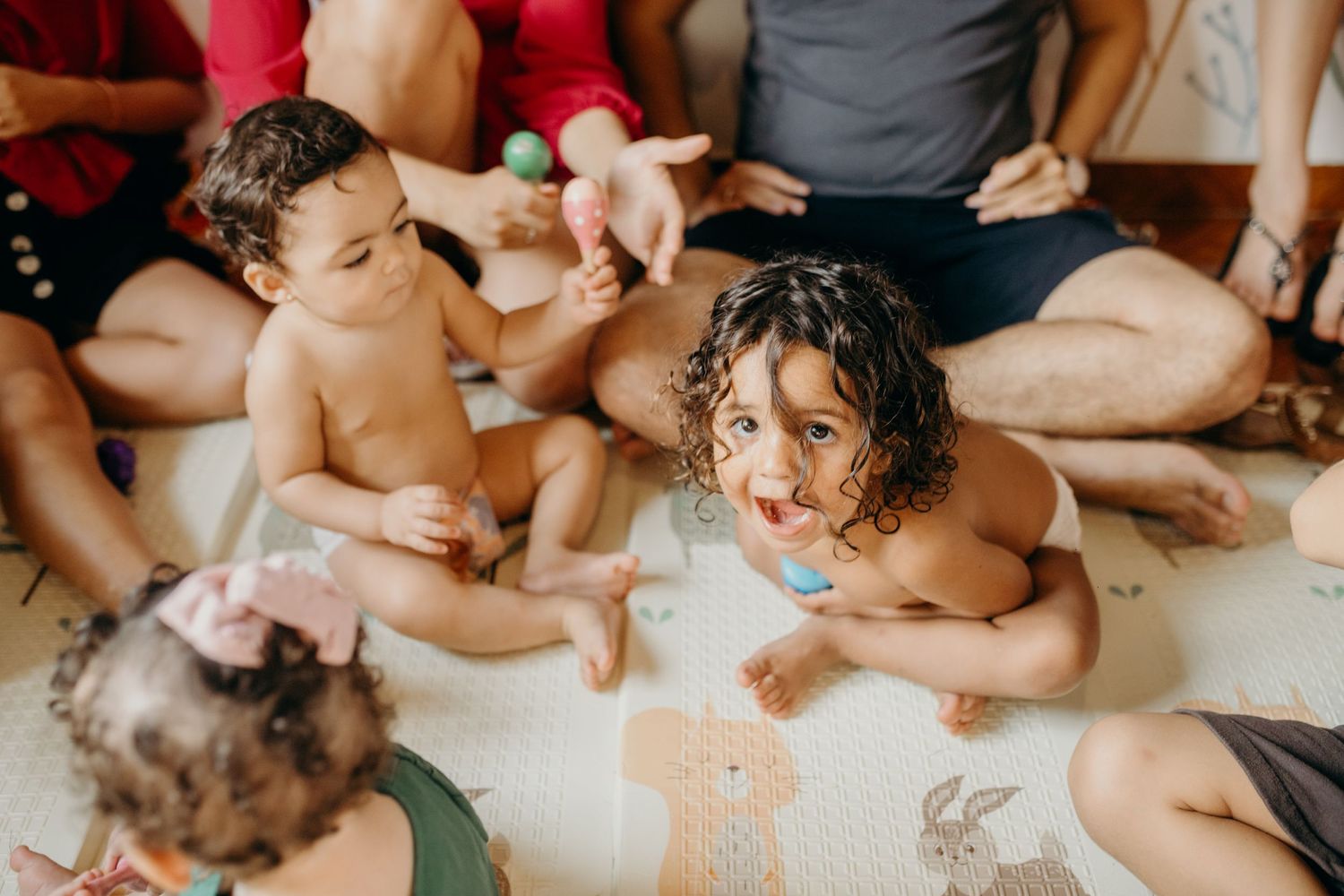 Group of children sitting on floor during indoor activity session.