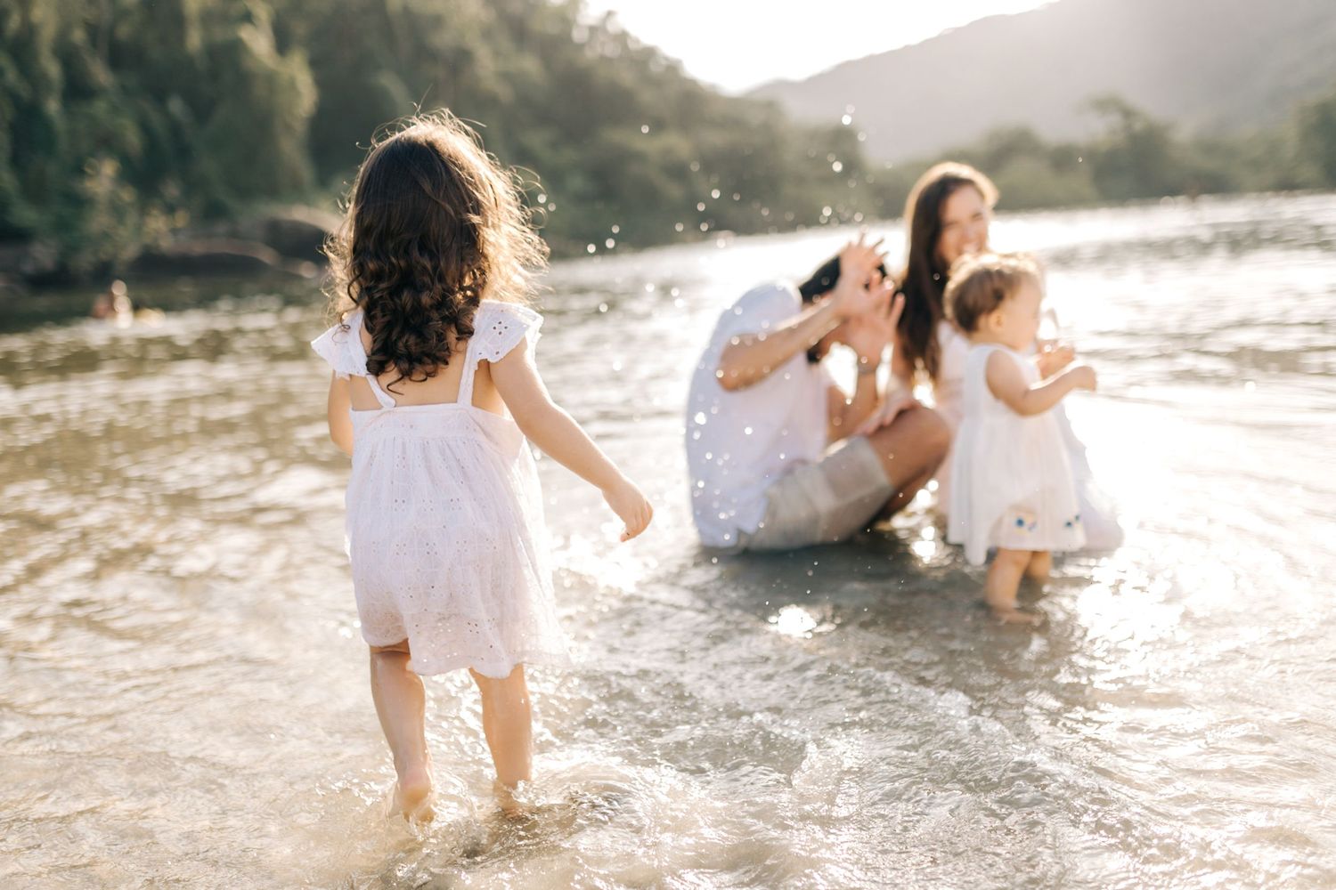Candid family photos capturing playful moments in beach water.