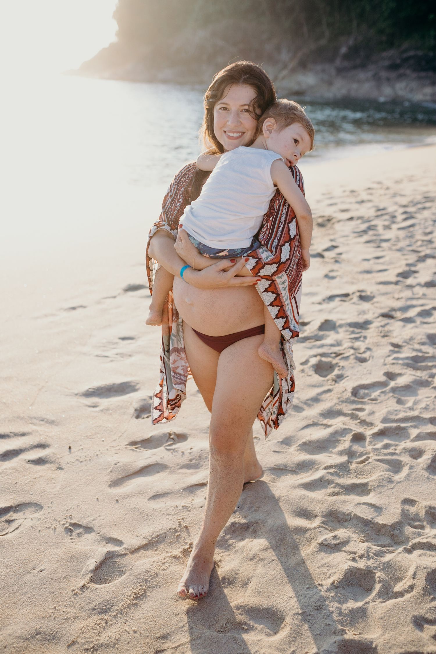 Seaside portrait with decorative orange wrap against coastal backdrop.