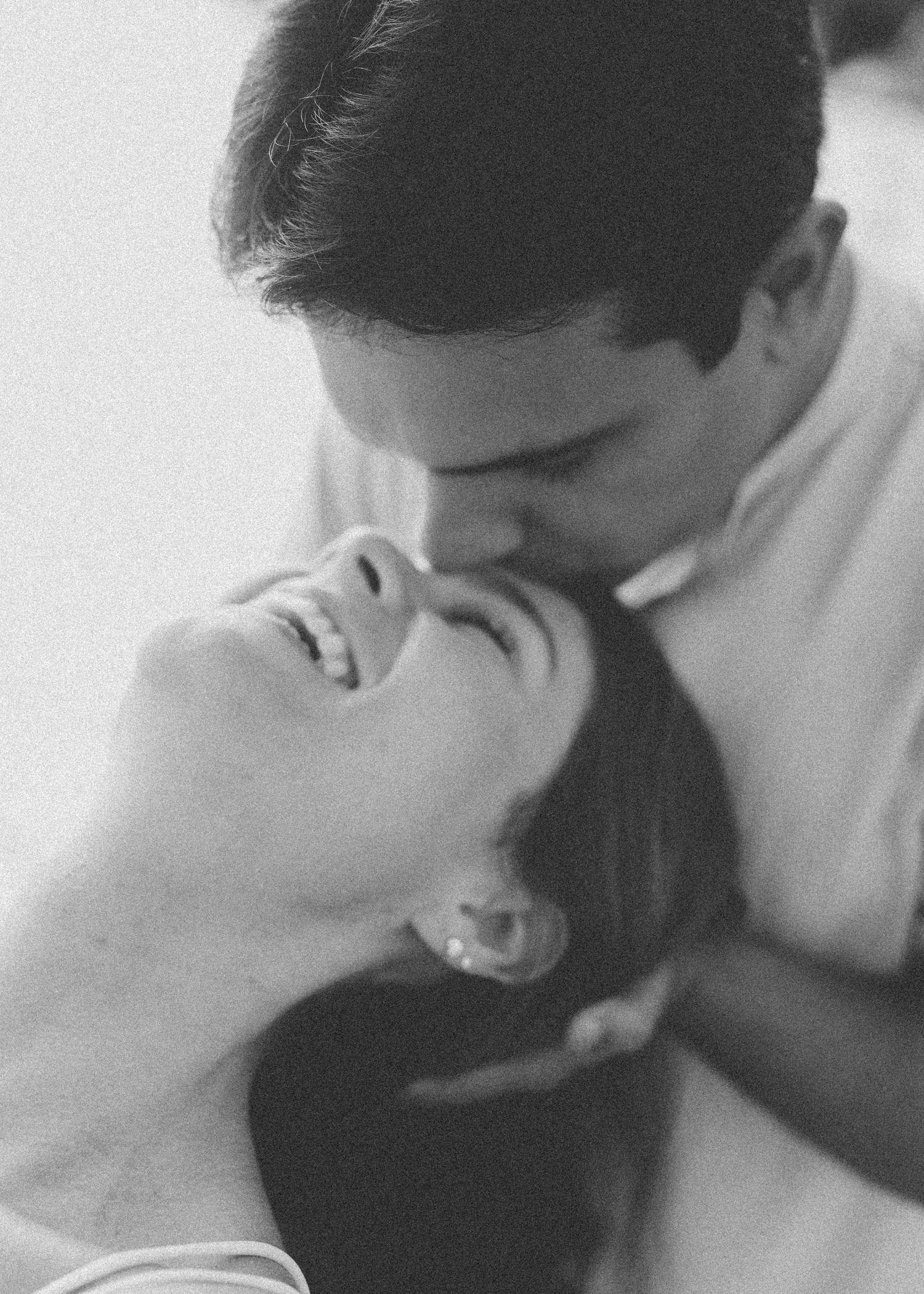 A romantic black and white portrait capturing an intimate moment between two people.