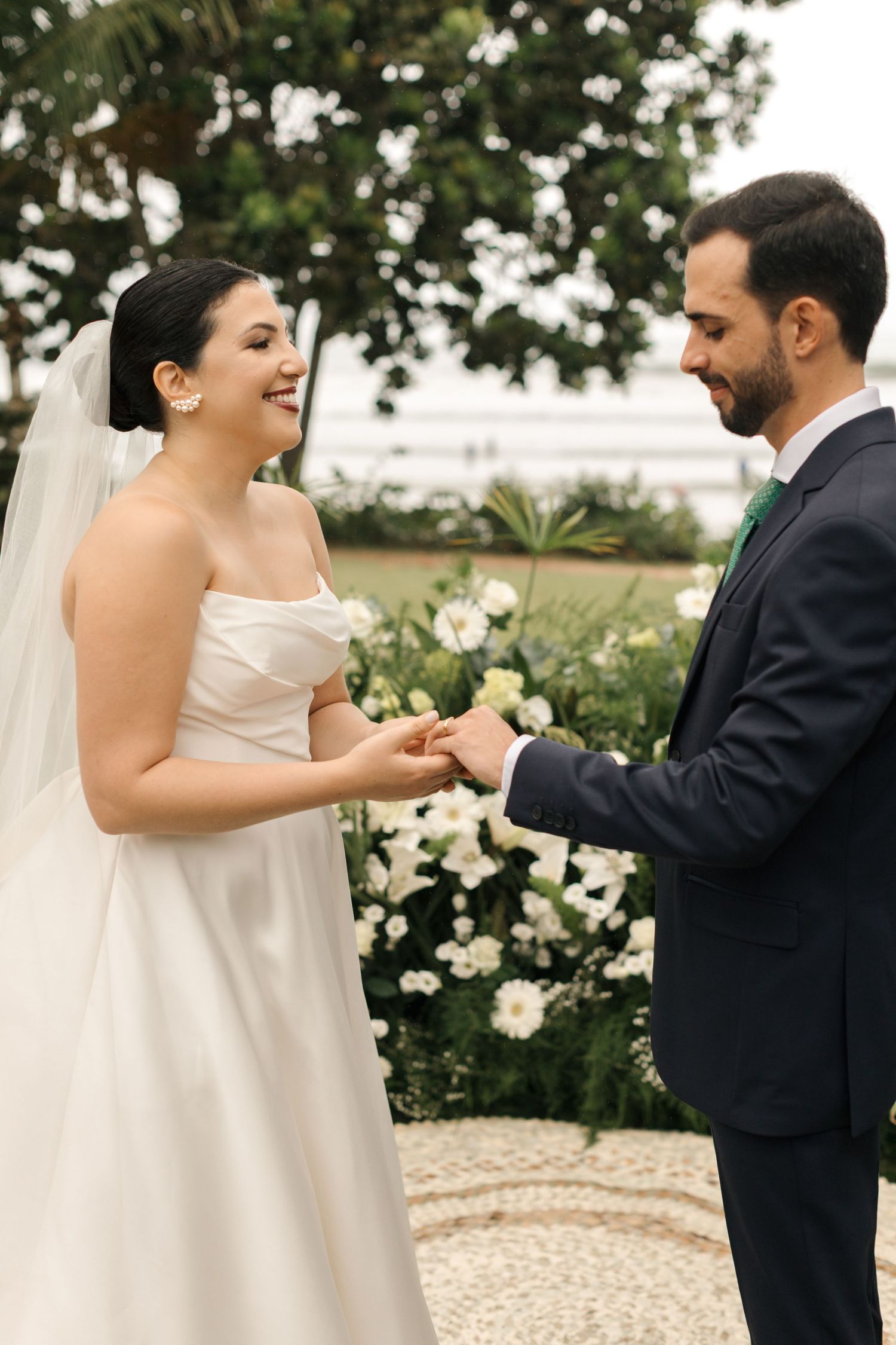 A joyful wedding ceremony moment captured in an outdoor garden setting with white flowers.