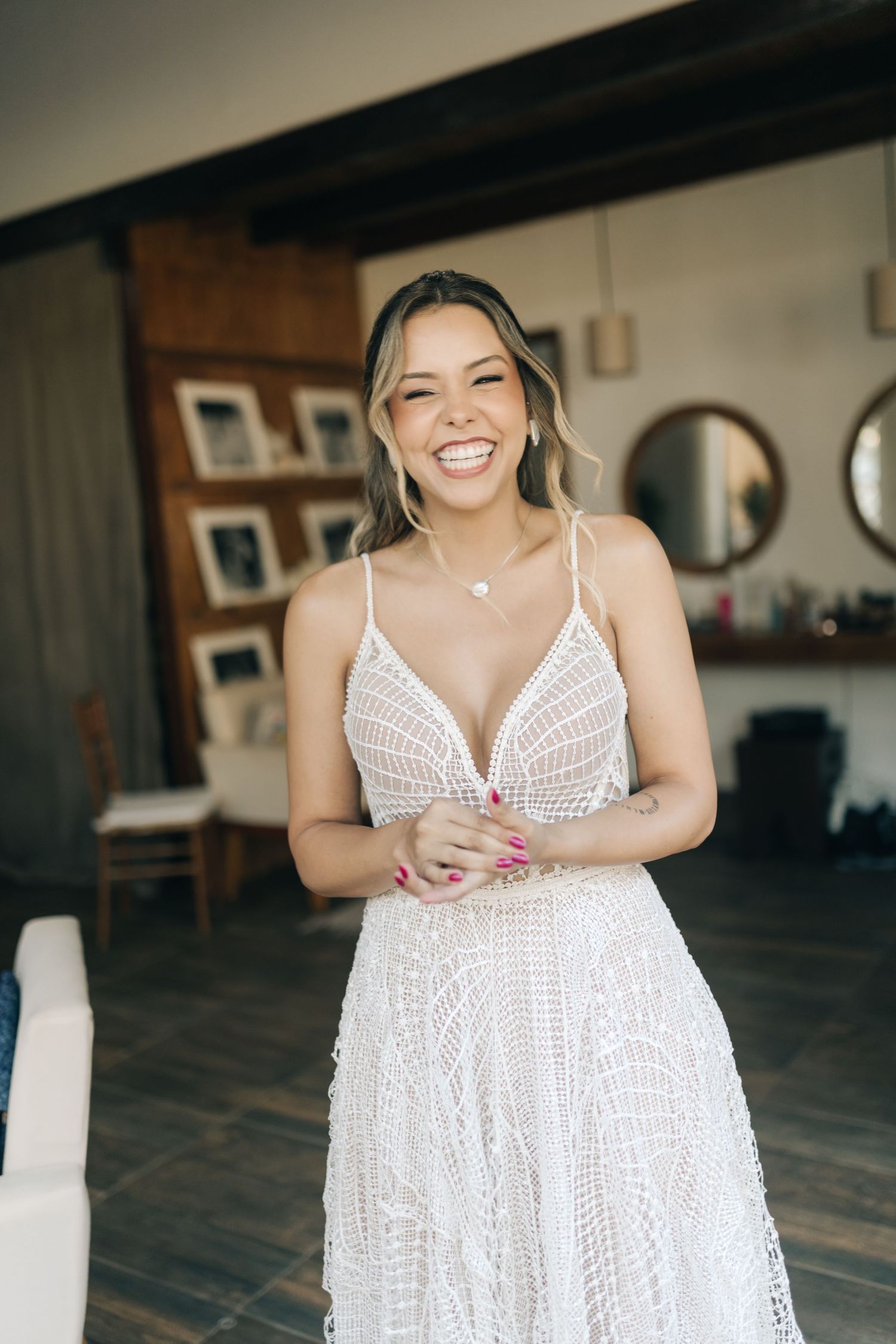 Multiple shots of white bridal dress with intricate lace detailing in indoor setting.