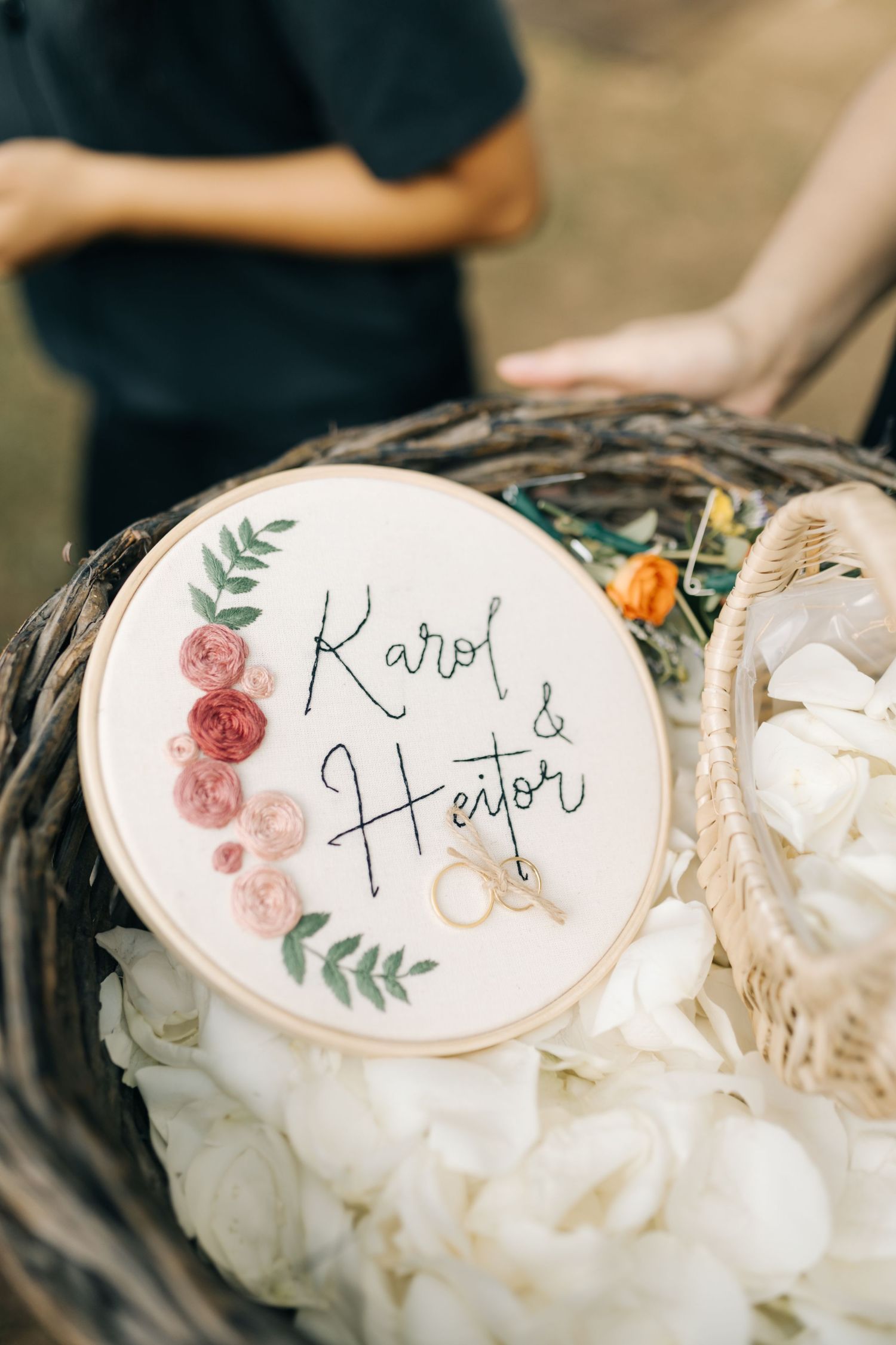 A decorative embroidery hoop displays names with floral designs at a wedding.