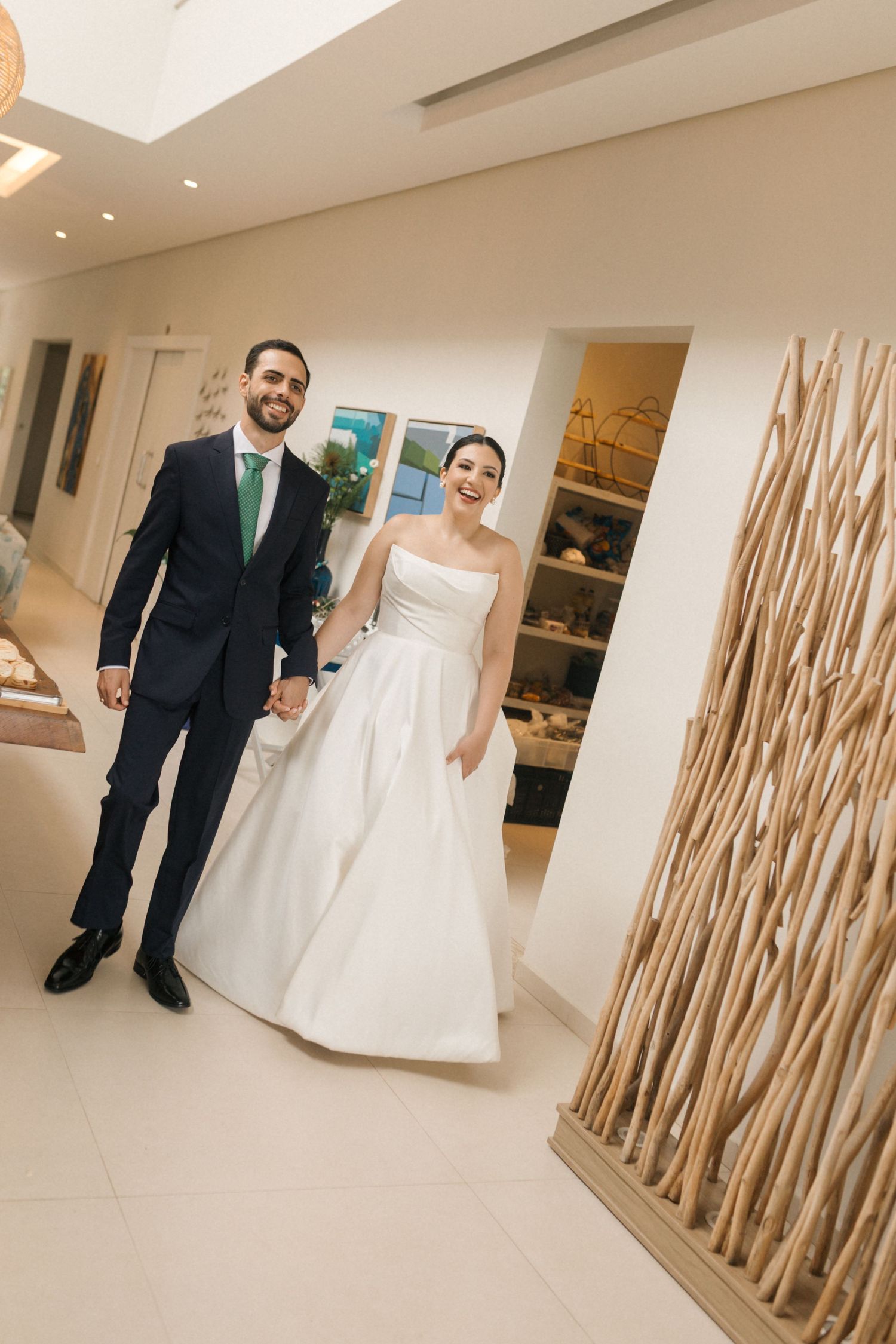 Wedding couple walking through an elegant hallway decorated with bamboo accents.