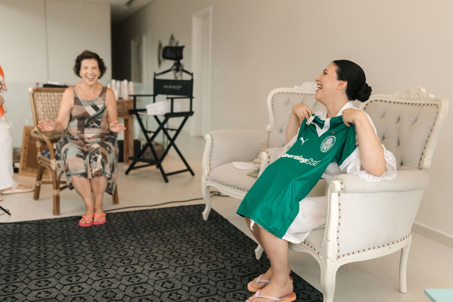 Two guests relaxing in elegant armchairs during a wedding celebration.