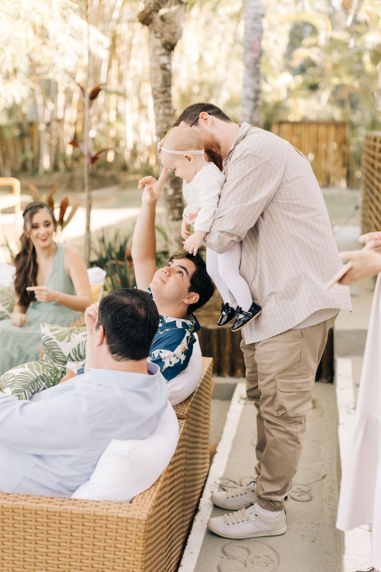 Family having fun at outdoor garden party with playful interactions.